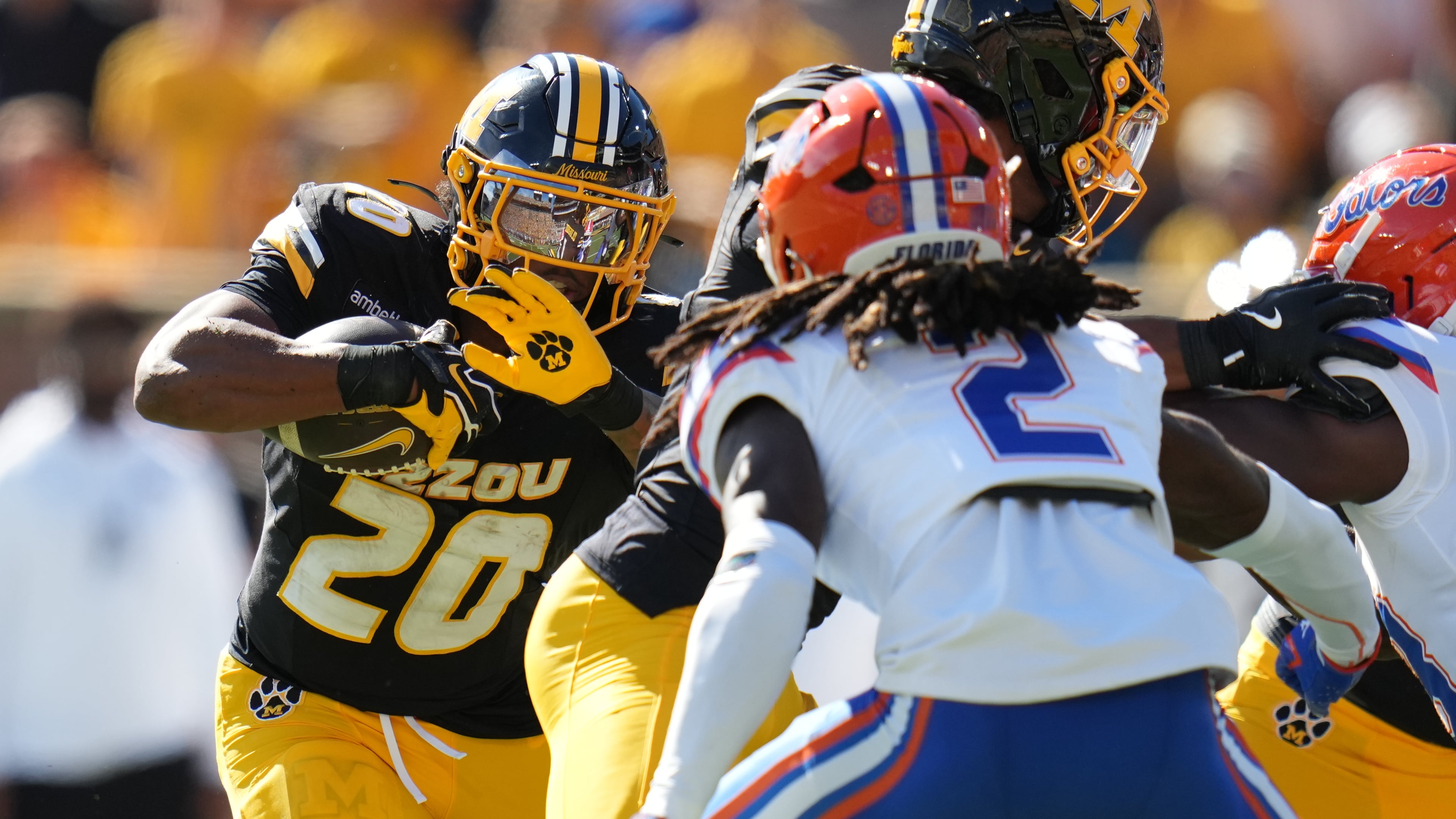 Missouri running back Jamal Roberts (20) runs with the ball as Florida safety Lagonza Hayward (2) defends during the first half of an NCAA college football game Saturday, Oct. 3, 2026, in Columbia, Mo. (AP Photo/Jeff Roberson)