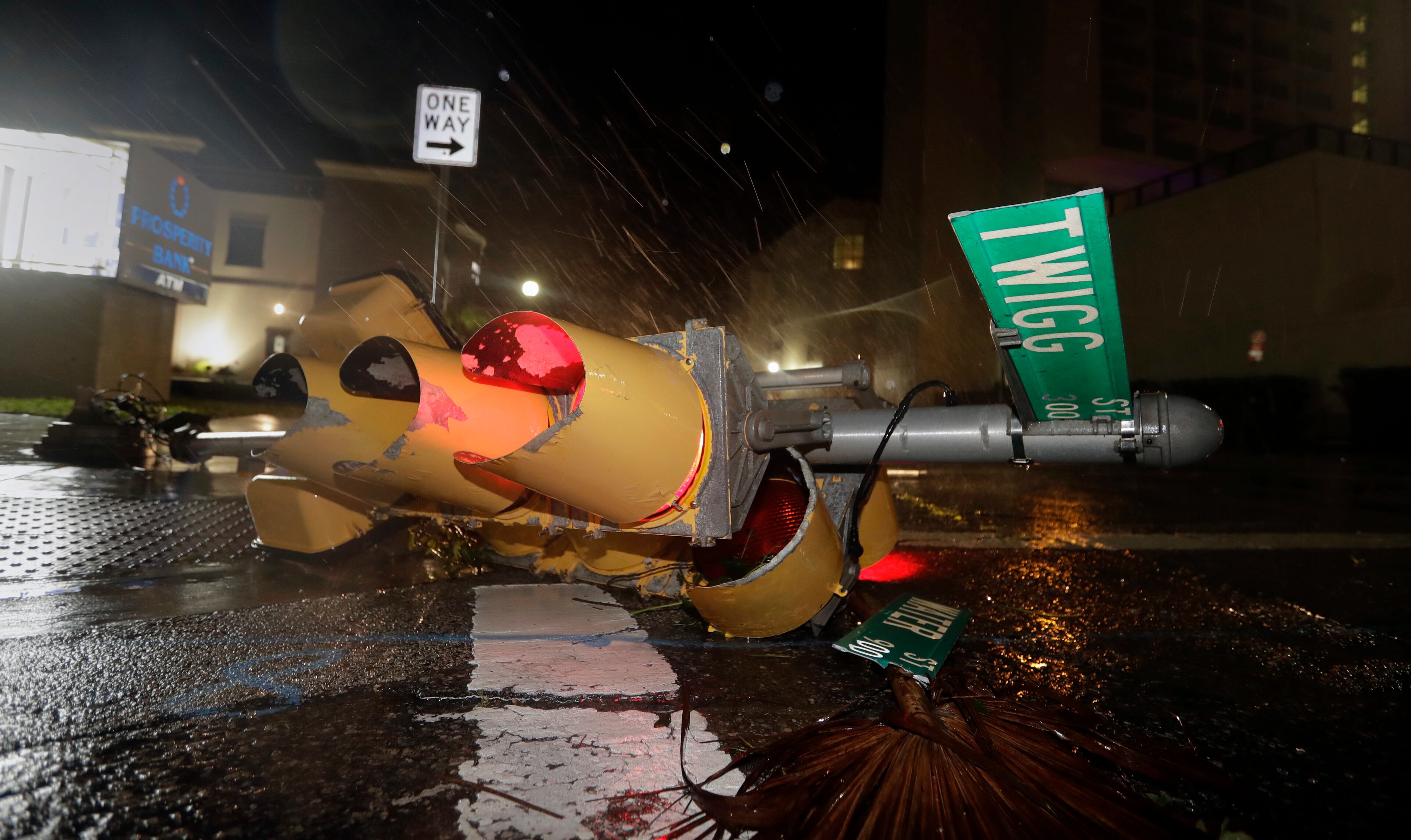 A traffic signal topped by the winds of Hurricane Harvey lies in an intersection of downtown Corpus Christi, Texas, Saturday, Aug. 26, 2017. Harvey has been further downgraded to a Category 1 hurricane as it churns slowly inland from the Texas Gulf Coast, already depositing more than 9 inches of rain in South Texas. (AP Photo/Eric Gay)
