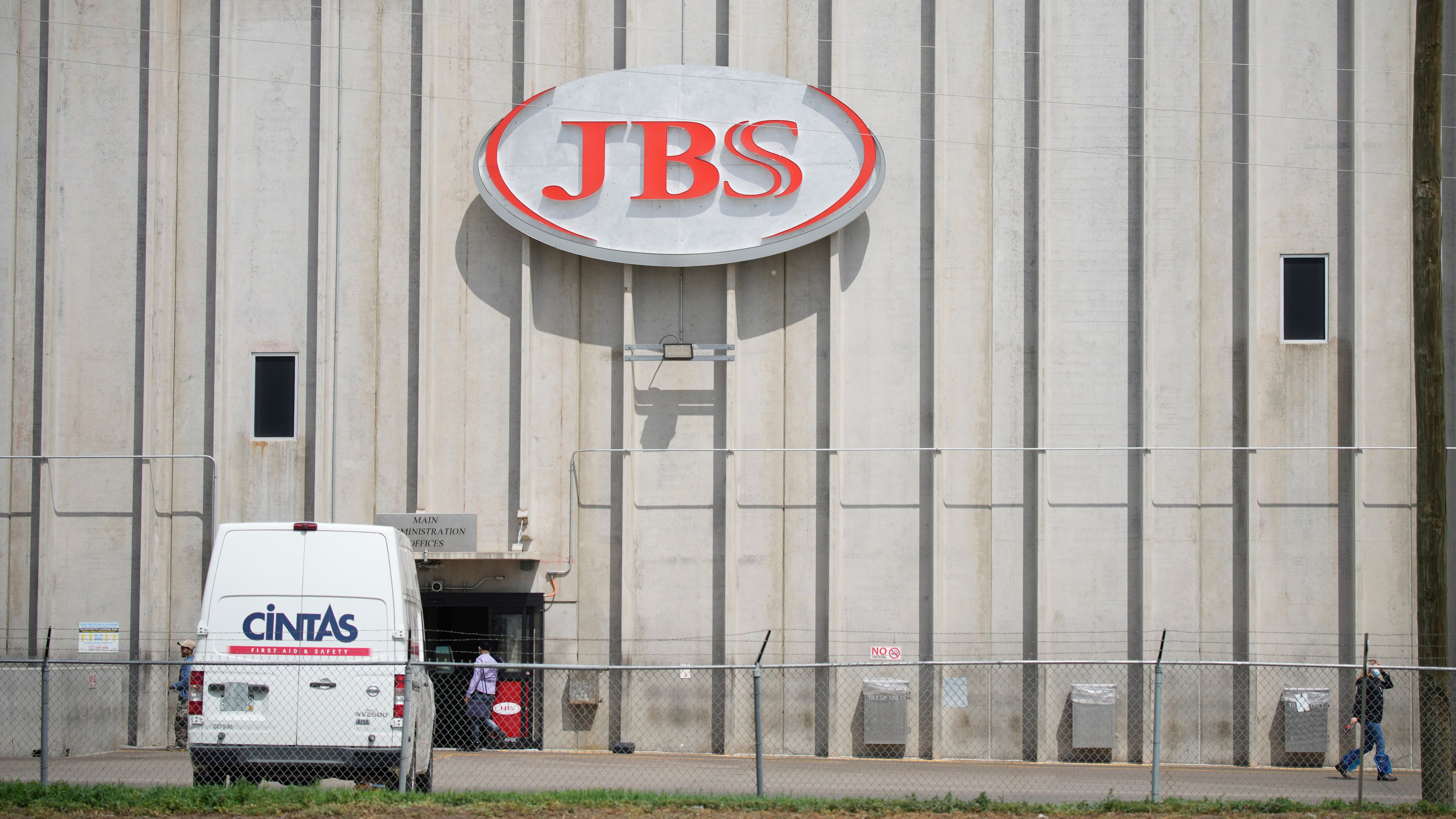 FILE - Employees walk in front of the entrance to the JBS meat processing plant, July 23, 2021, in Greeley, Colo. (AP Photo/David Zalubowski, File)