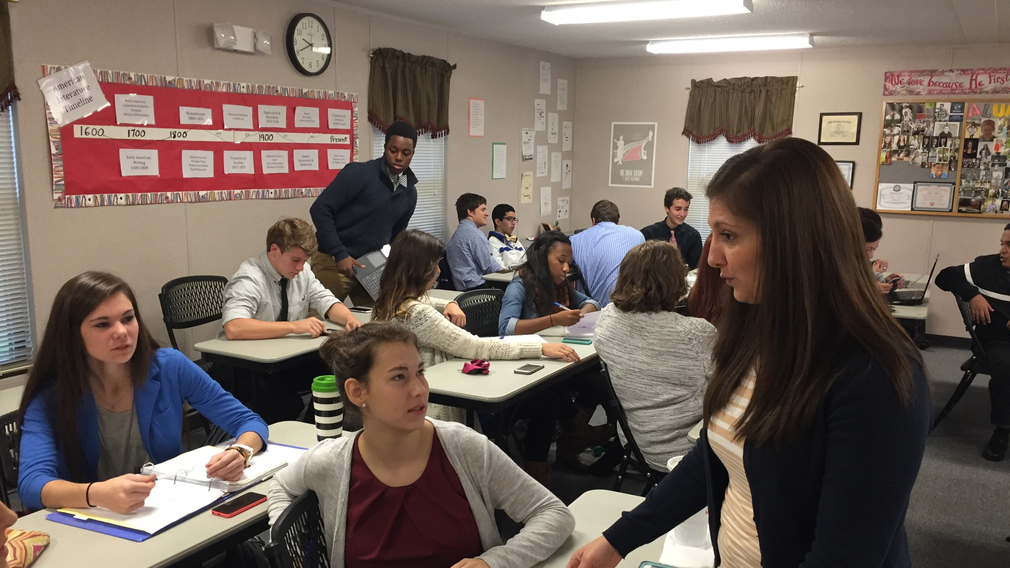 North Cobb Christian student Reagan Carr (seated) exchanges ideas with instructor Amber Timms (standing) during a dual-enrollment English class. A partnership between NCC and Shorter University set up college-level courses on the school’s Kennesaw campus.
