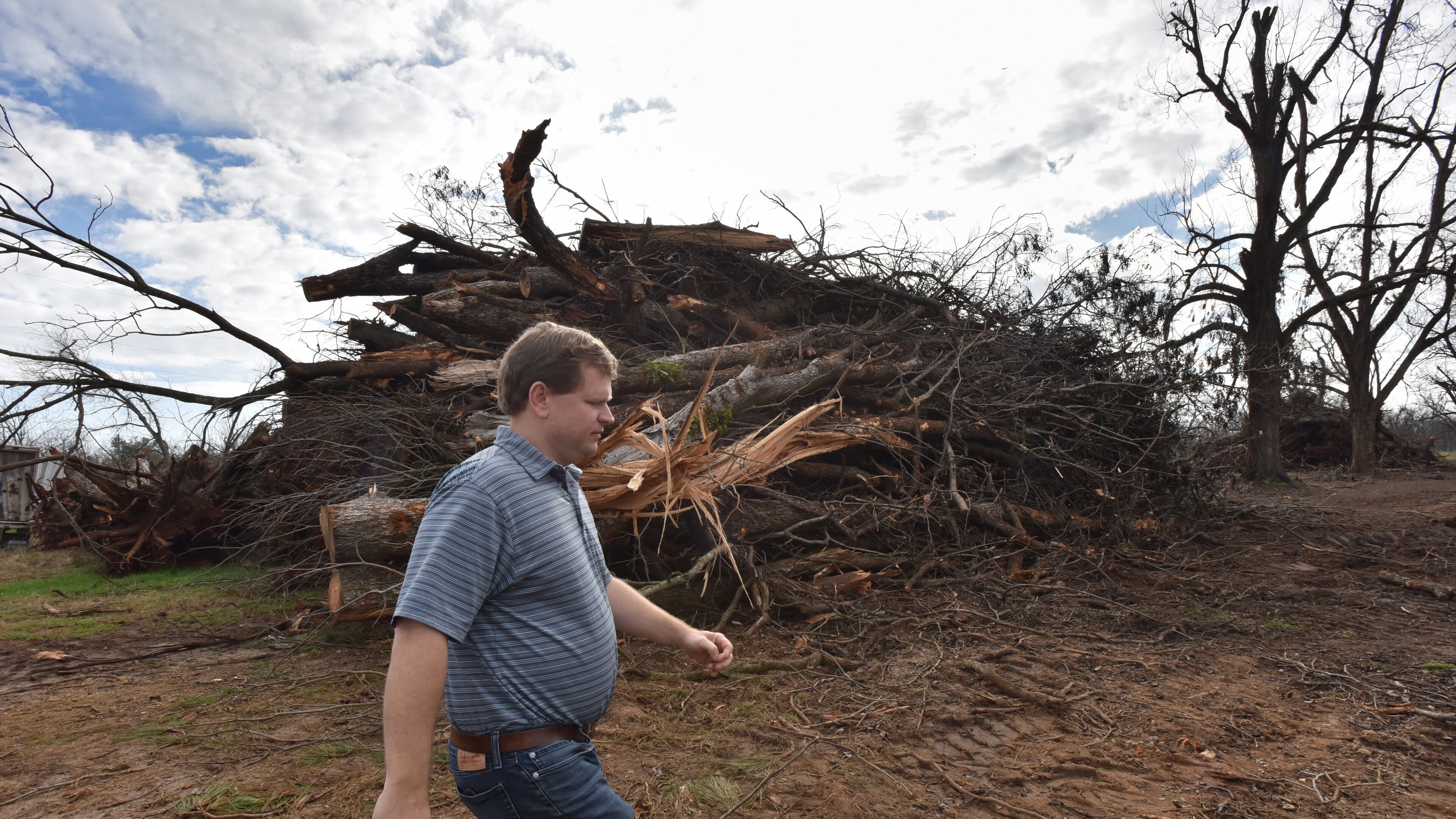 Farmer Trey Pippin walks past a pile of dead pecan trees at his farm in Albany on Feb. 5, 2019. South Georgia farmers were hit hard by Hurricane Michael in October 2018. HYOSUB SHIN / HSHIN@AJC.COM