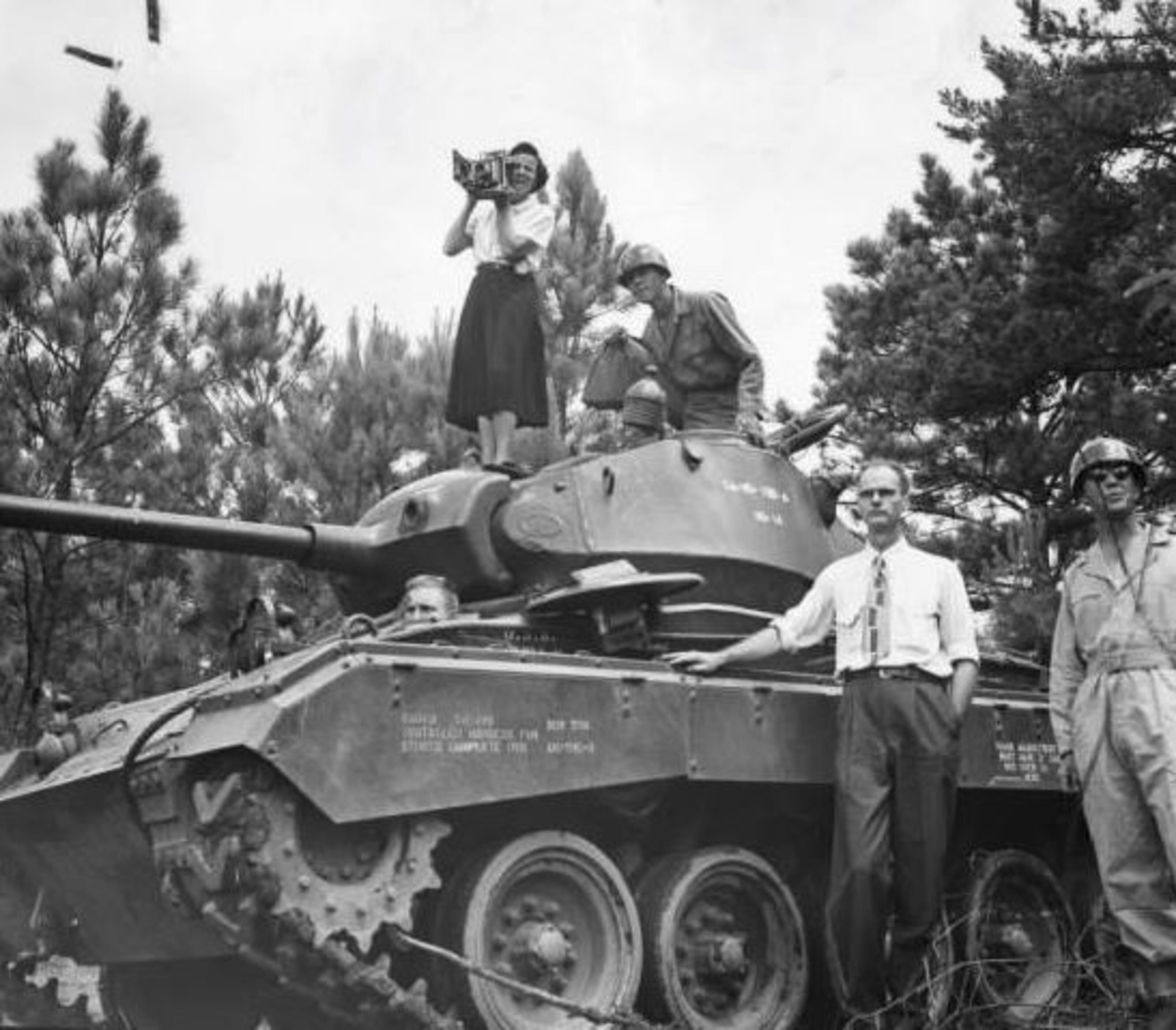 1950 -- Carolyn Carter, the first woman photographer for The Atlanta Constitution, climbs atop a light tank. Willard Neal, at the right, wrote the story. AJC PHOTO ARCHIVES
