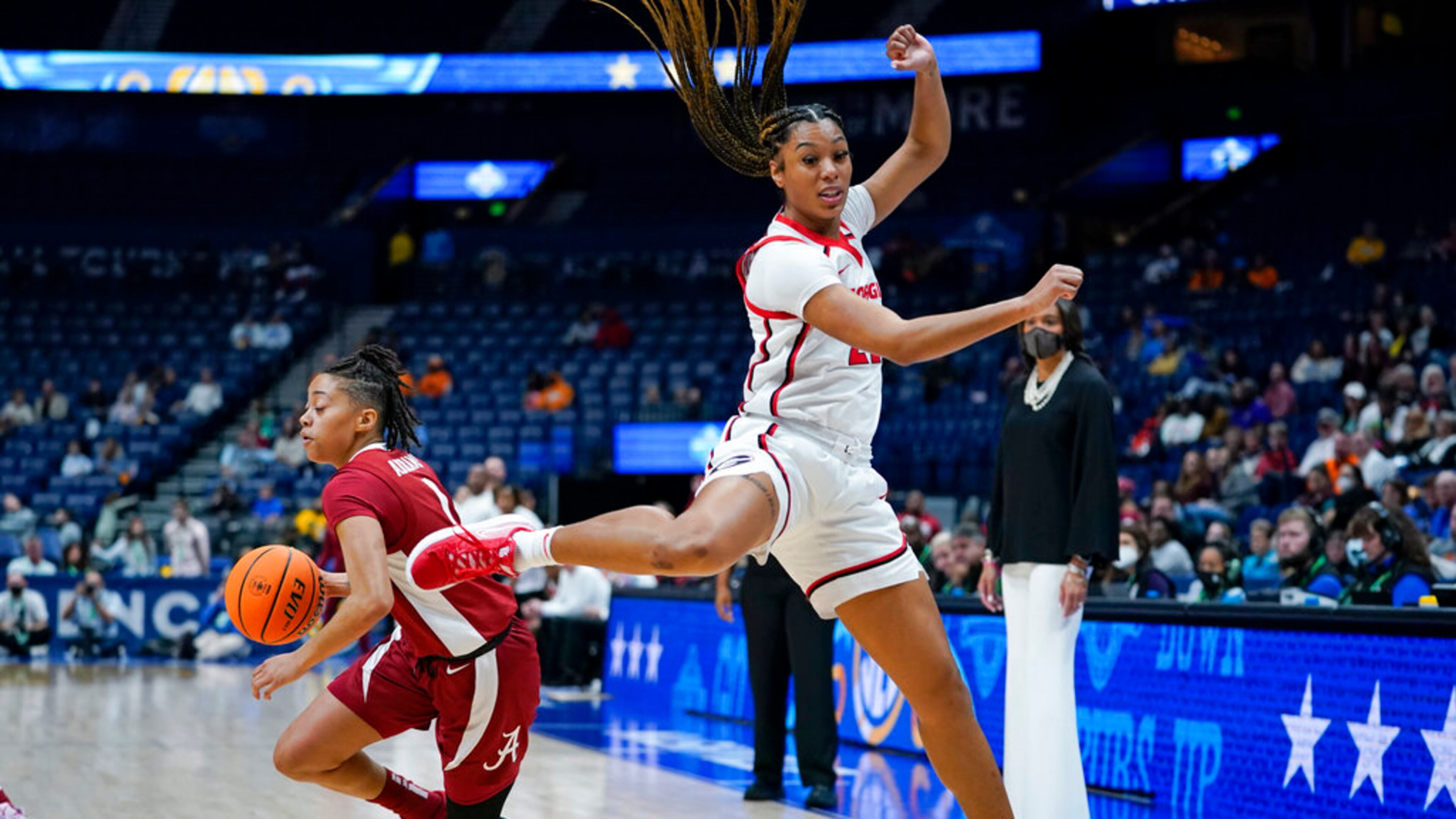 Georgia's Reigan Richardson (21) sails past Alabama's Megan Abrams (1) in the first half of an NCAA college basketball game at the women's Southeastern Conference tournament Thursday, March 3, 2022, in Nashville, Tenn. (AP Photo/Mark Humphrey)