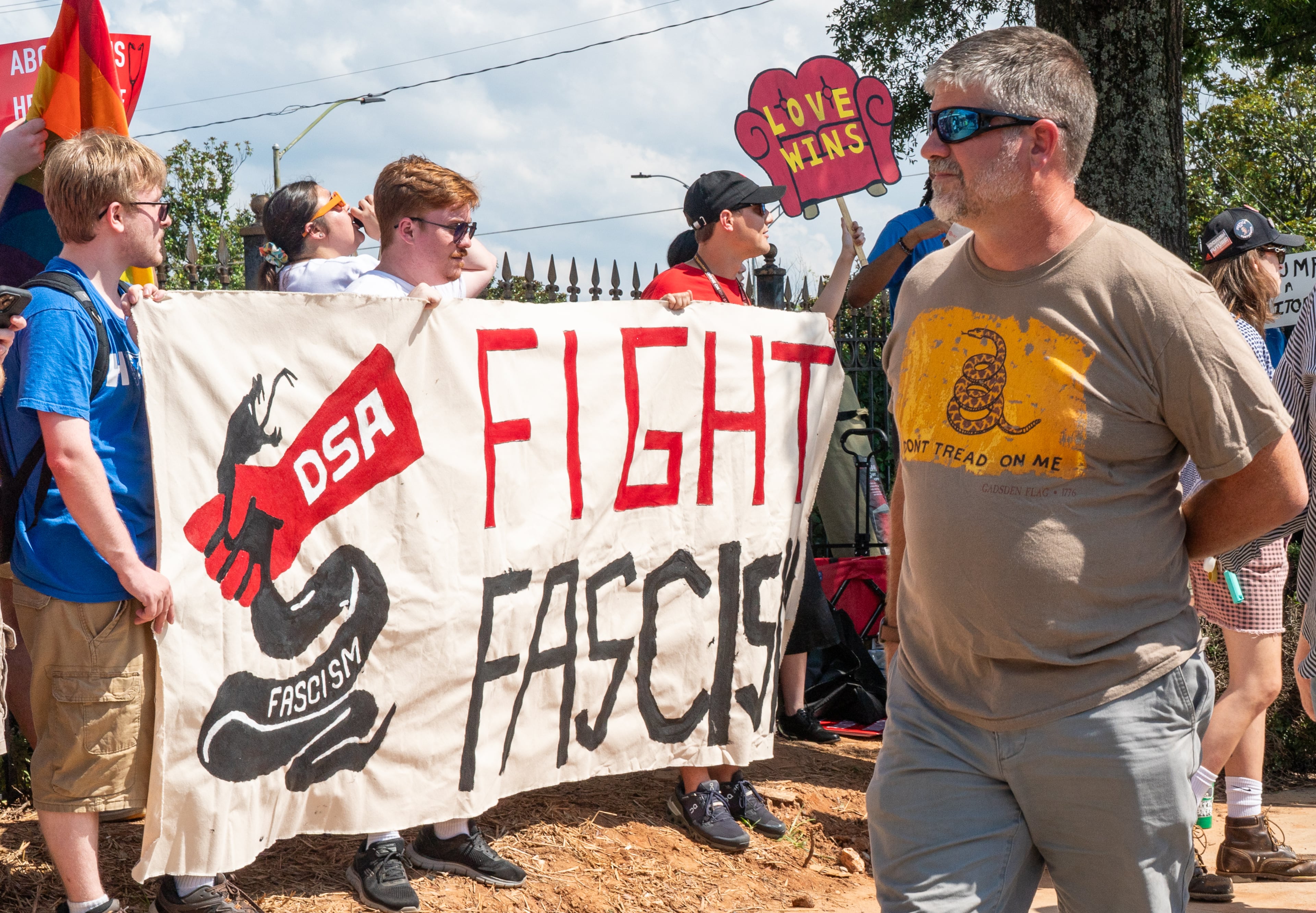 Trump rally attendees walk past a Democratic Socialists of America protest outside the Georgia State Convocation Center in Atlanta. (Seeger Gray/AJC 2024)