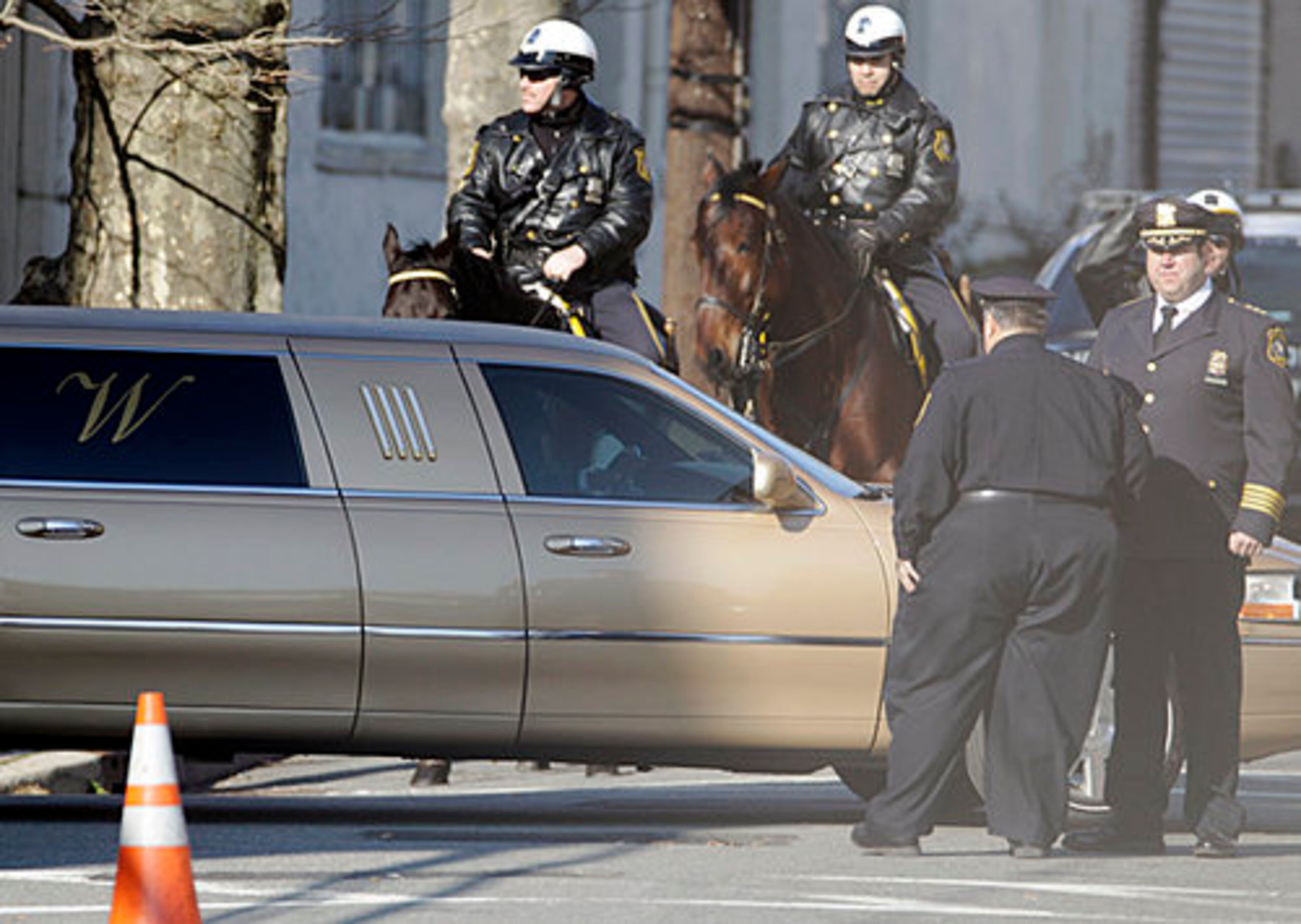 A funeral home limousine passes policemen near the New Hope Baptist Church in Newark, N.J., Saturday, Feb. 18, 2012.