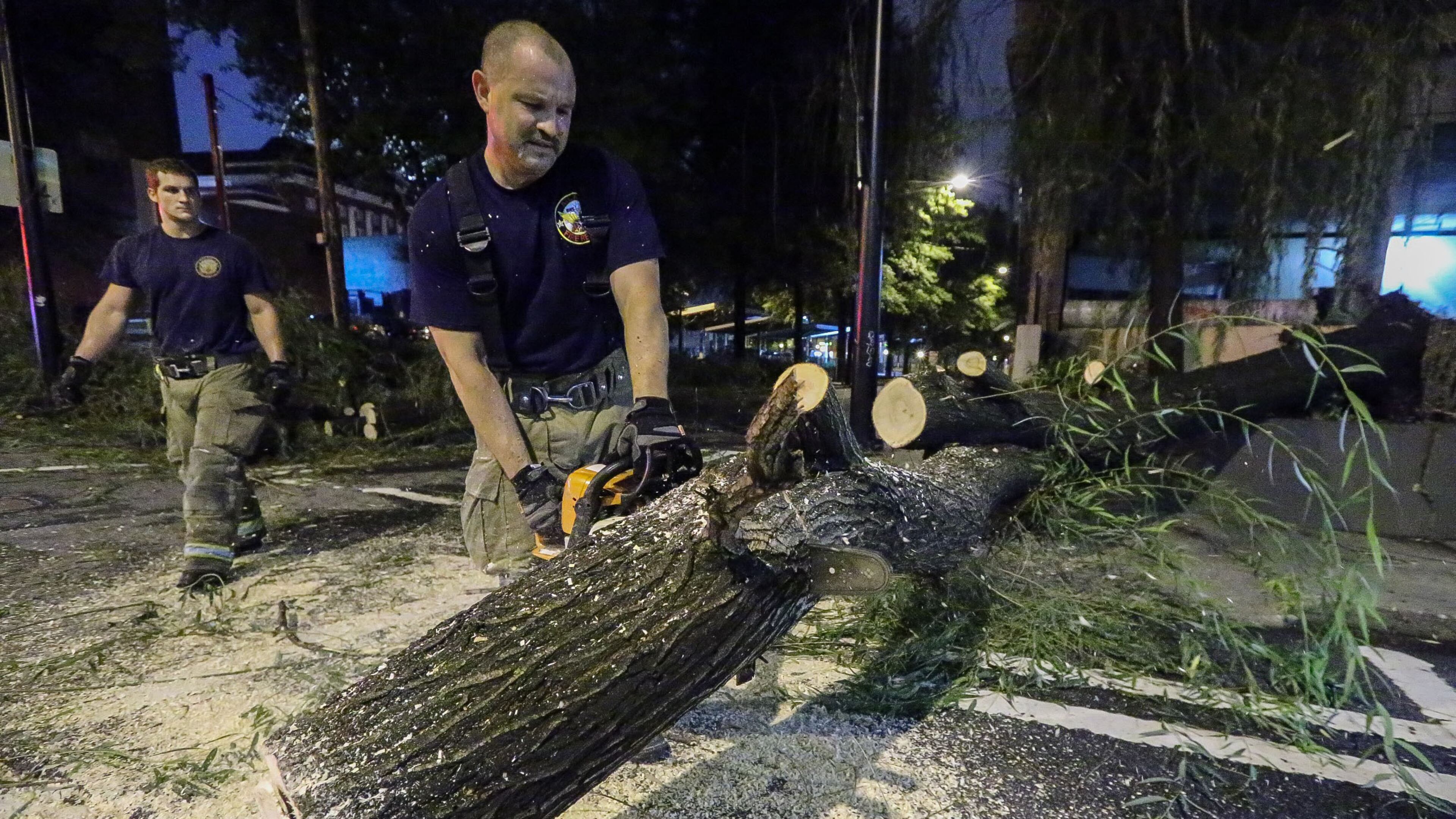 Workers cut up a tree that fell Thursday morning at Williams and Spring streets in Downtown Atlanta.
