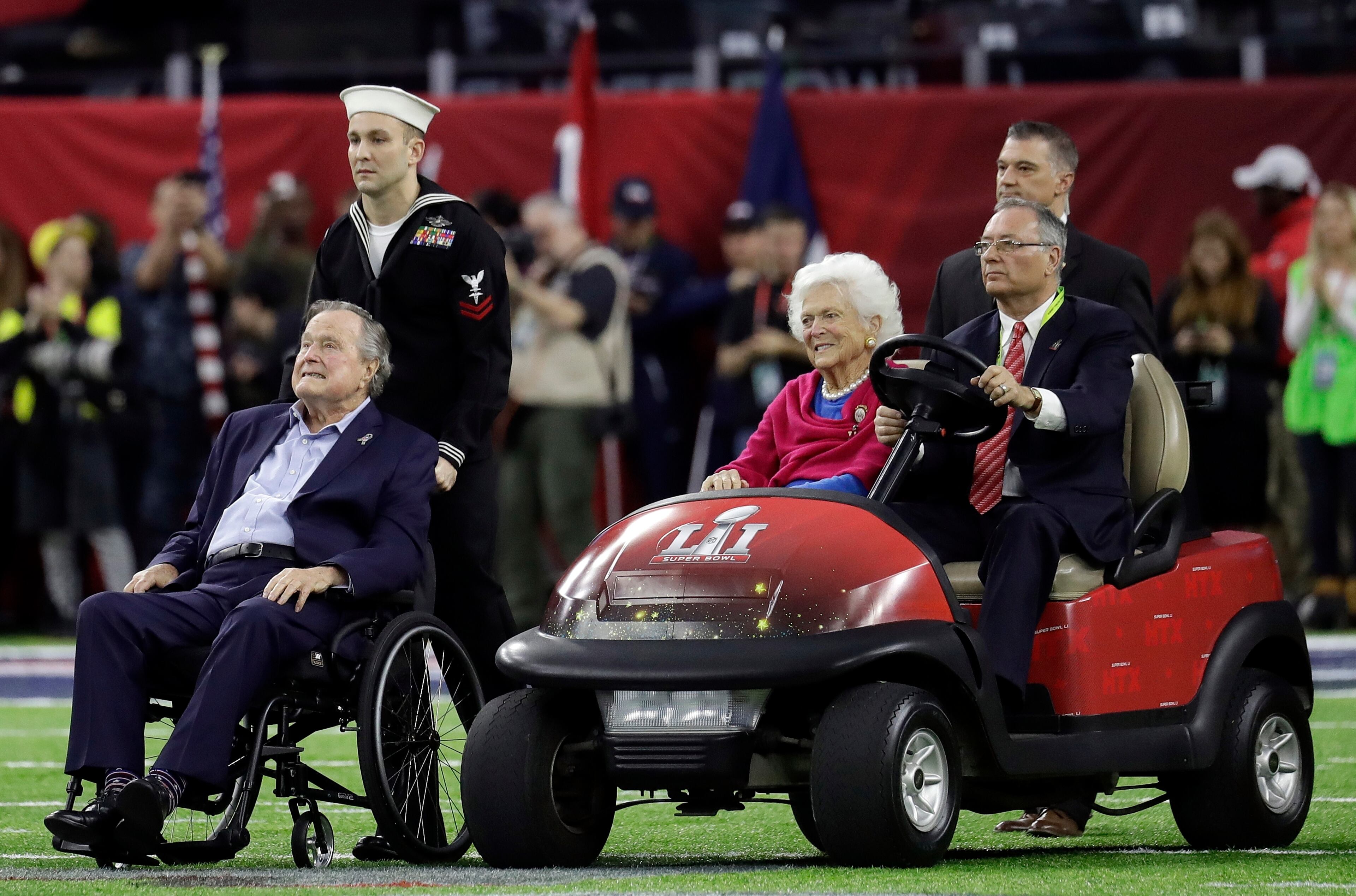 Former President George H.W. Bush and wife, Barbara arrive on the field for a coin toss before the NFL Super Bowl 51 football game between the Atlanta Falcons and the New England Patriots Sunday, Feb. 5, 2017, in Houston. (AP Photo/Eric Gay)