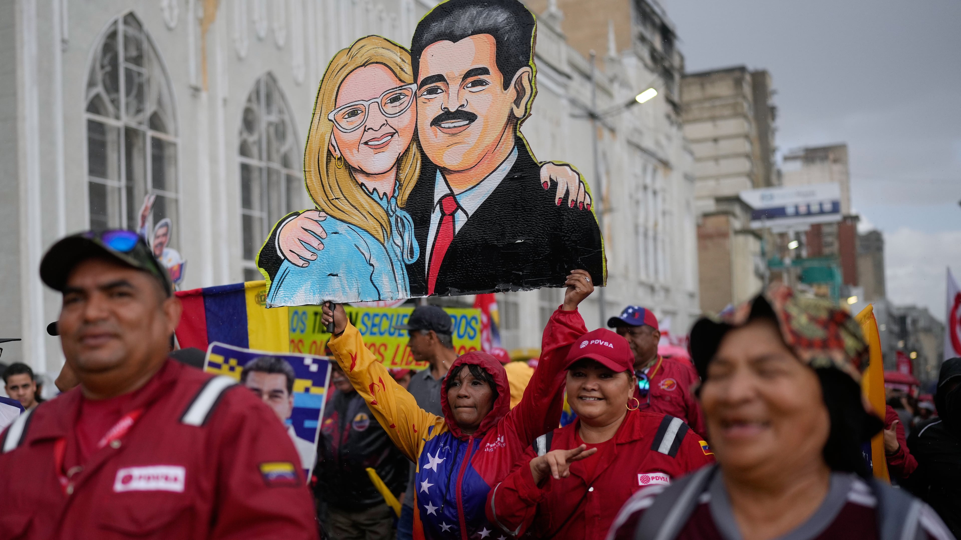 Government supporters carry a cutout of former President Nicolás Maduro and his wife Cilia Flores during a rally marking the anniversary of the 1958 coup that overthrew Venezuelan dictator Marcos Pérez Jiménez, in Caracas, Venezuela, Friday, Jan. 23, 2026. (AP Photo/Ariana Cubillos)