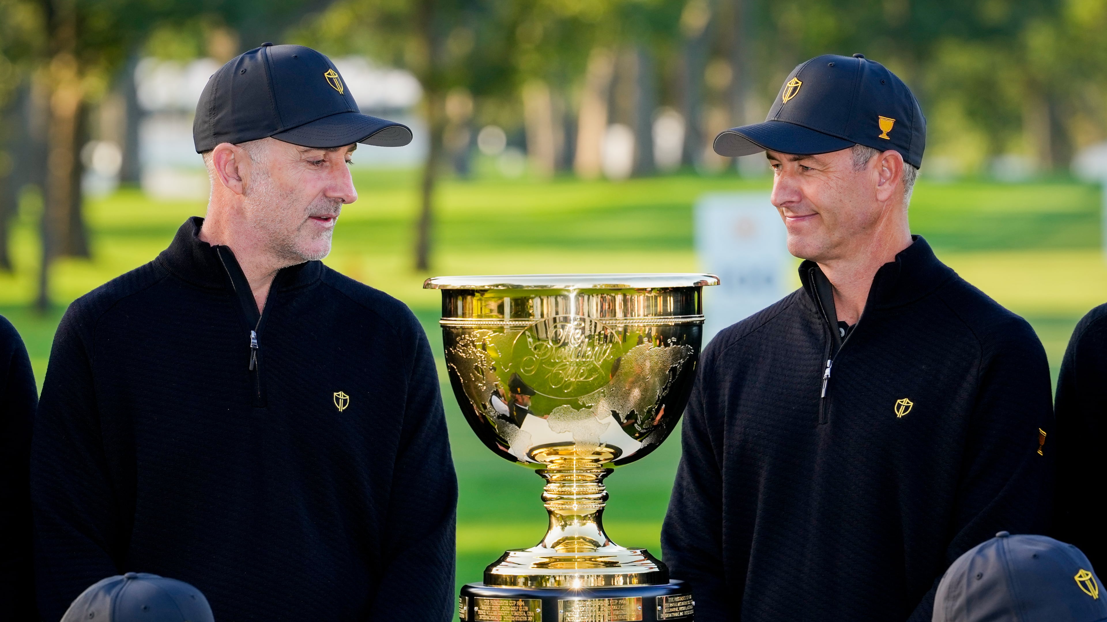International team captain Geoff Ogilvy, of Australia, left, and player Adam Scott, of Australia, look at the Presidents Cup trophy during a team portrait prior to the start of the Presidents Cup golf tournament against the USA team at Medinah Country Club, Wednesday, Sept. 23, 2026, in Medinah, Ill. (AP Photo/Matt Slocum)