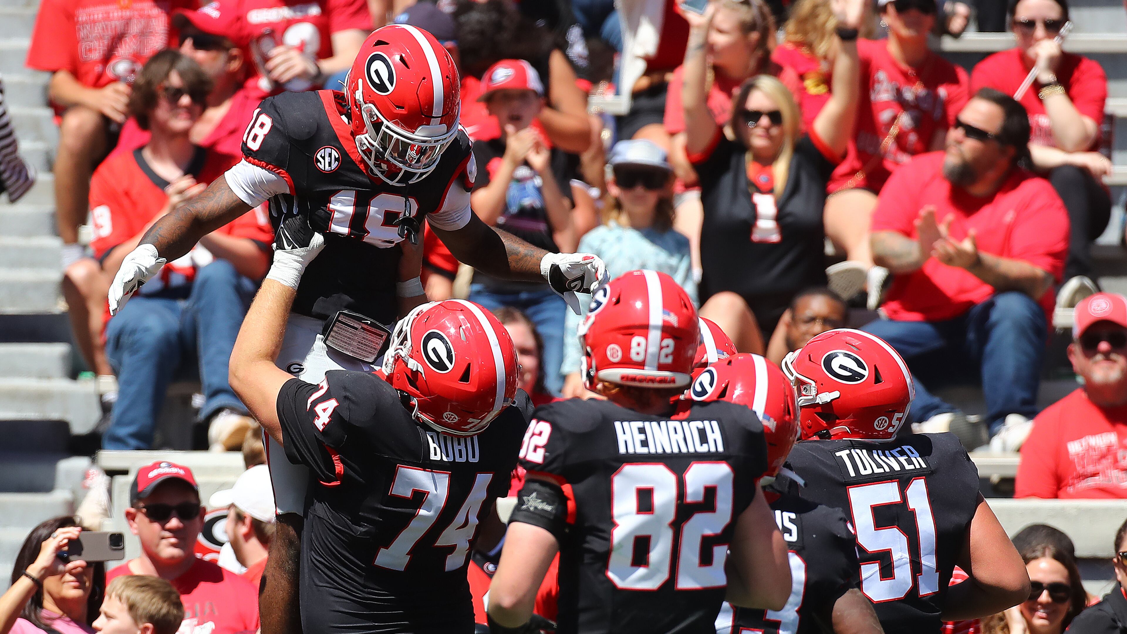 041324 Athens: Drew Bobo (74) hoists receiver Sacovie White in the air after White scored a touchdown to give the black team a 17-13 lead during the G-Day game on Saturday, April 13, 2024. Curtis Compton for the Atlanta Journal Constitution