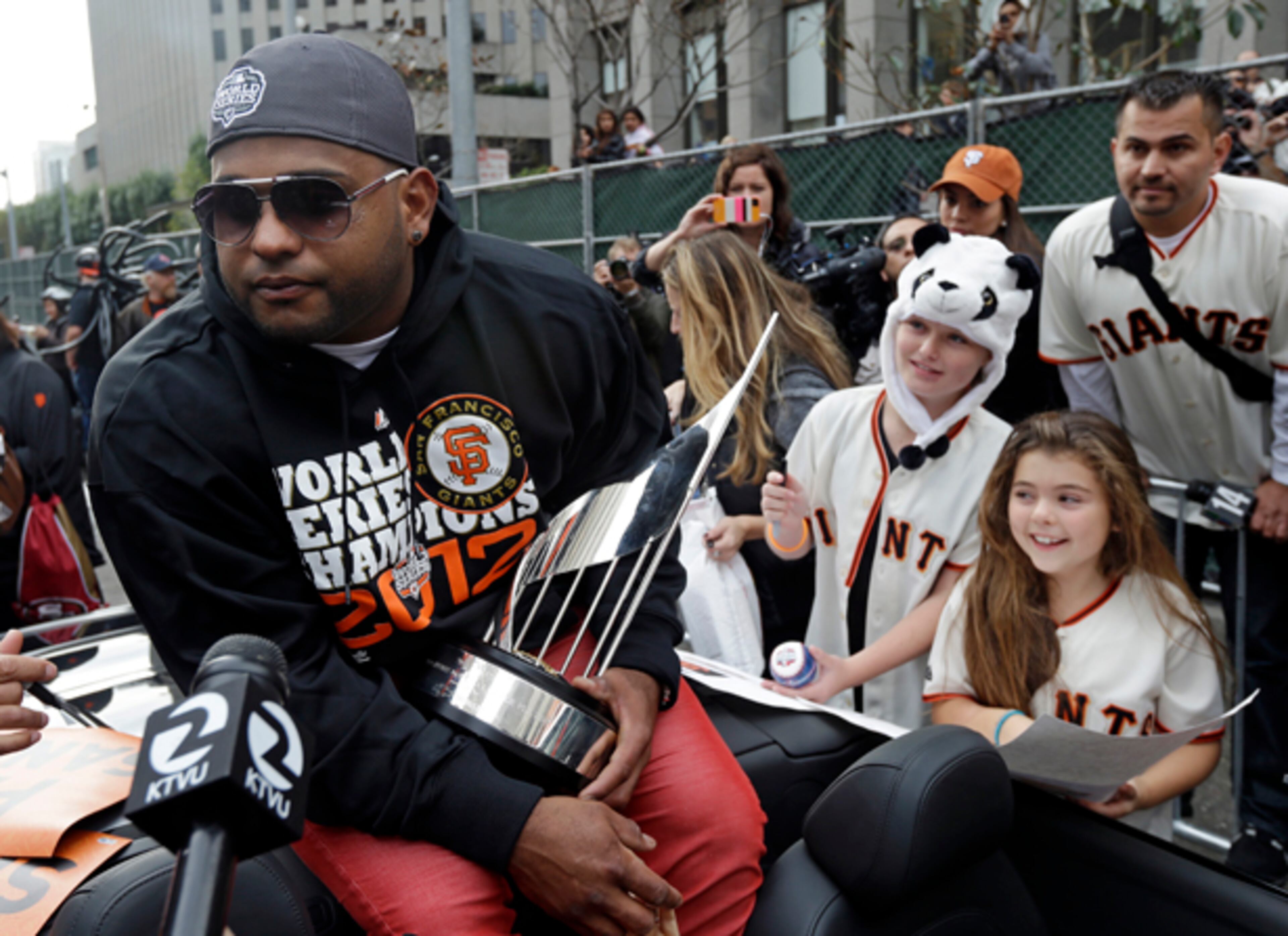 San Francisco Giants Pablo Sandoval holds the MVP trophy as kids wait for his autograph before the start of the victory parade in San Francisco, Wednesday, Oct. 31, 2012. The Halloween Day World Series victory parade is perfectly suited for the hundreds of thousands of orange-and-black-clad Giants fans expected to flood into the city. The team's second championship in three years will head down Market Street Wednesday afternoon and end with a celebration in front of City Hall. (AP Photo/Marcio Jose Sanchez)