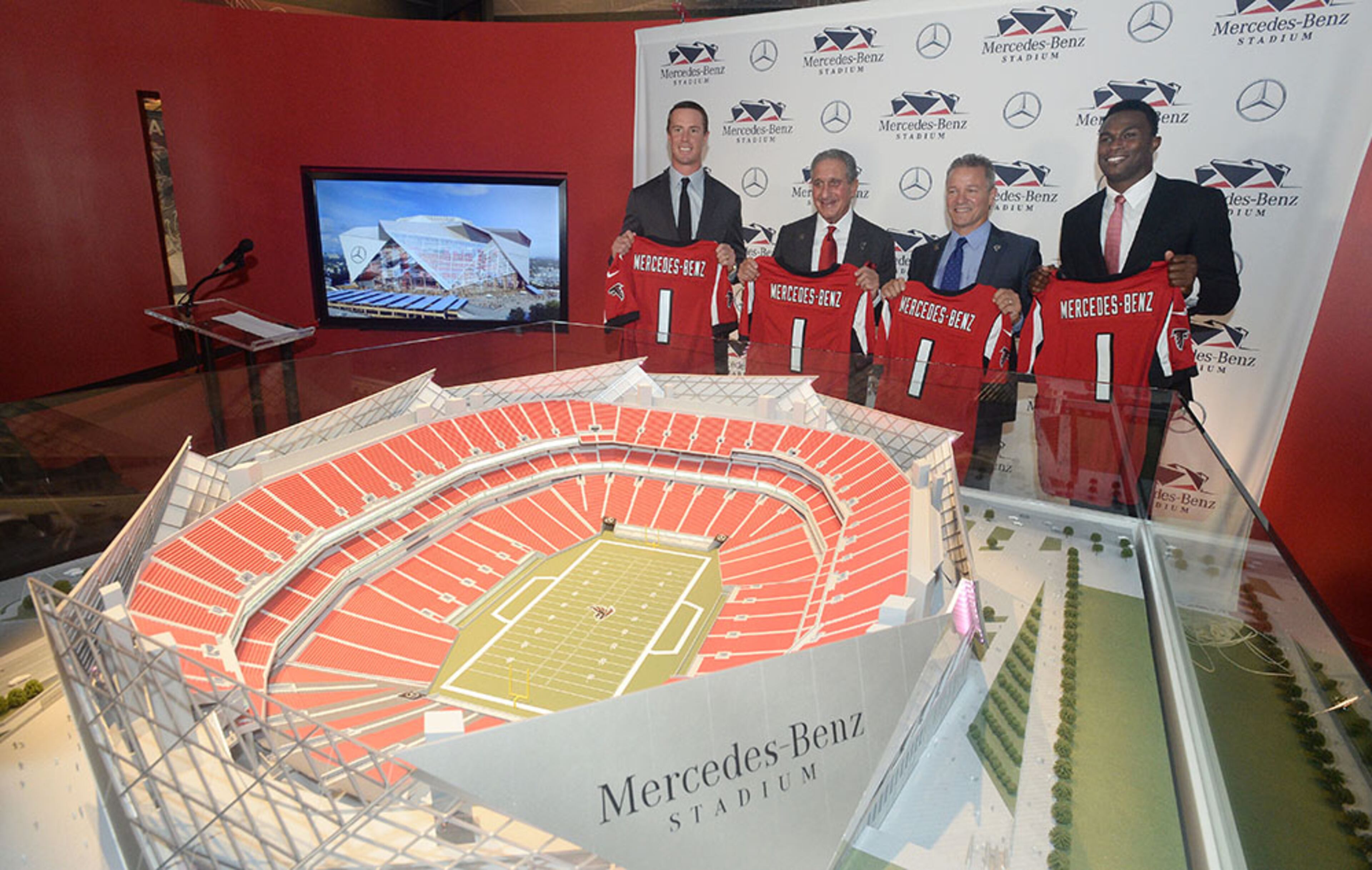 Matt Ryan (from left), Arthur Blank, Stephen Cannon and Julio Jones pose with a model of the new Falcons stadium, following announcement of deal Mercedes-Benz would pay for naming rights for new facility under construction in downtown Atlanta.