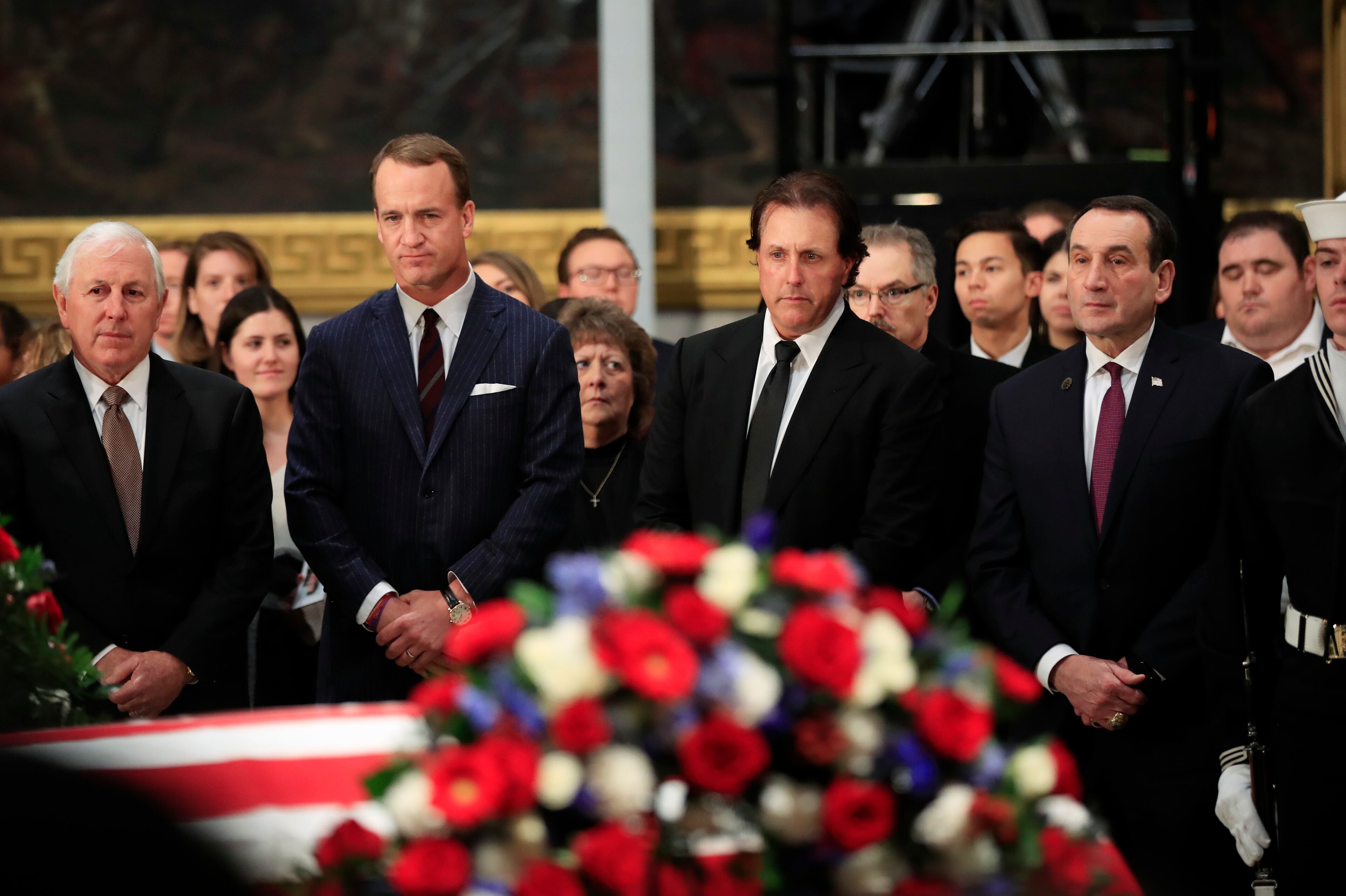 Former NFL football quarterback Peyton Manning, second from left to right, PGA golfer Phil Mickelson, Duke head basketball coach Mike Krzyzewski and professional golfer Hale Irwin, left, pay their last respects to former President George H.W. Bush as he lies in state at the U.S. Capitol in Washington, Tuesday, Dec. 4, 2018.