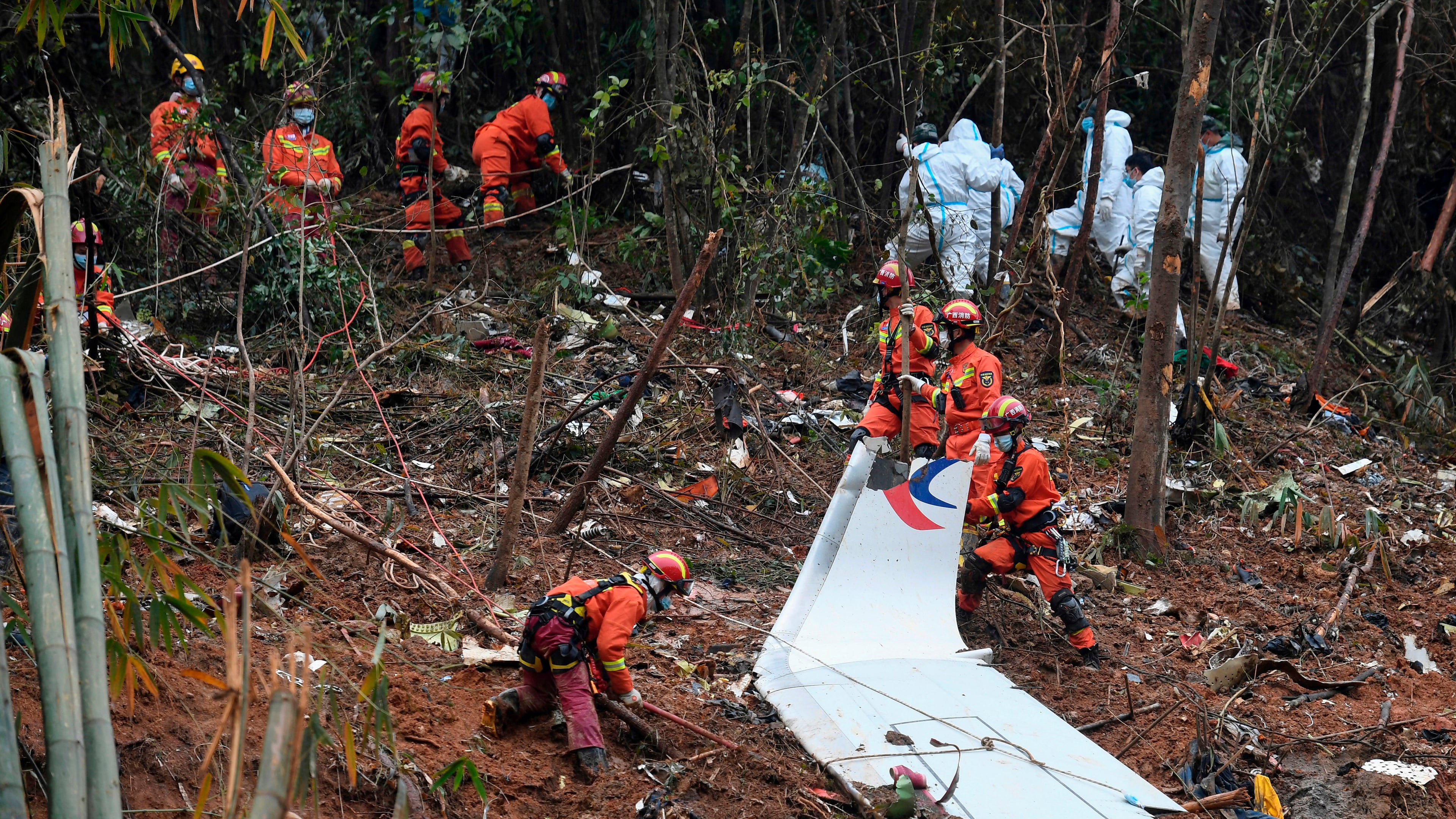 FILE - In this photo released by Xinhua News Agency, search and rescue workers search through debris at the China Eastern flight crash site in Tengxian County in southern China's Guangxi Zhuang Autonomous Region on March 24, 2022. (Lu Boan/Xinhua via AP, File)