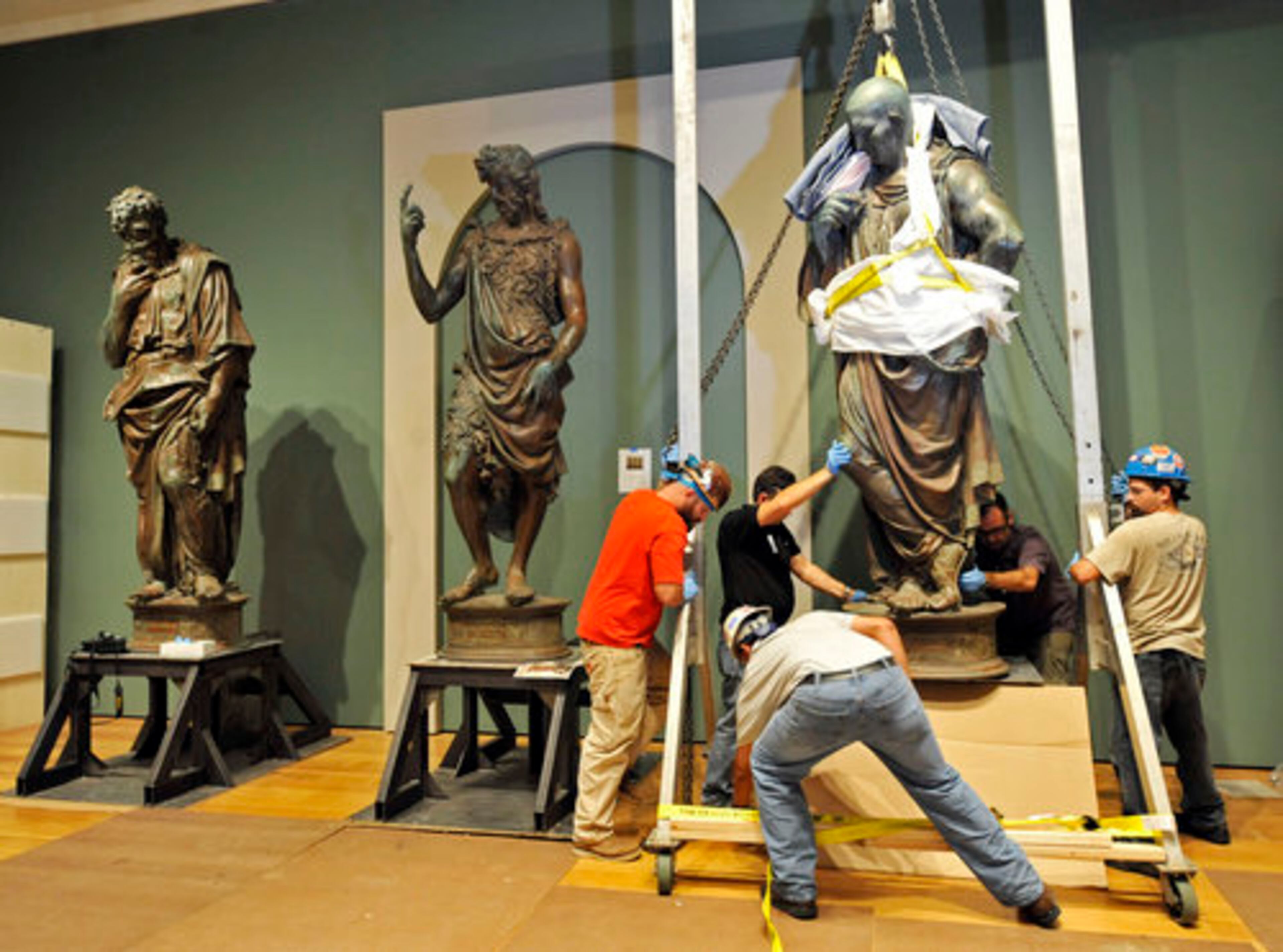 Workers move into place the last of three bronze figures by Giovan Francesco Rustici that will be part of the first exhibition to explore Leonardo da Vinci's influence on sculpture at the High. The show runs through February.