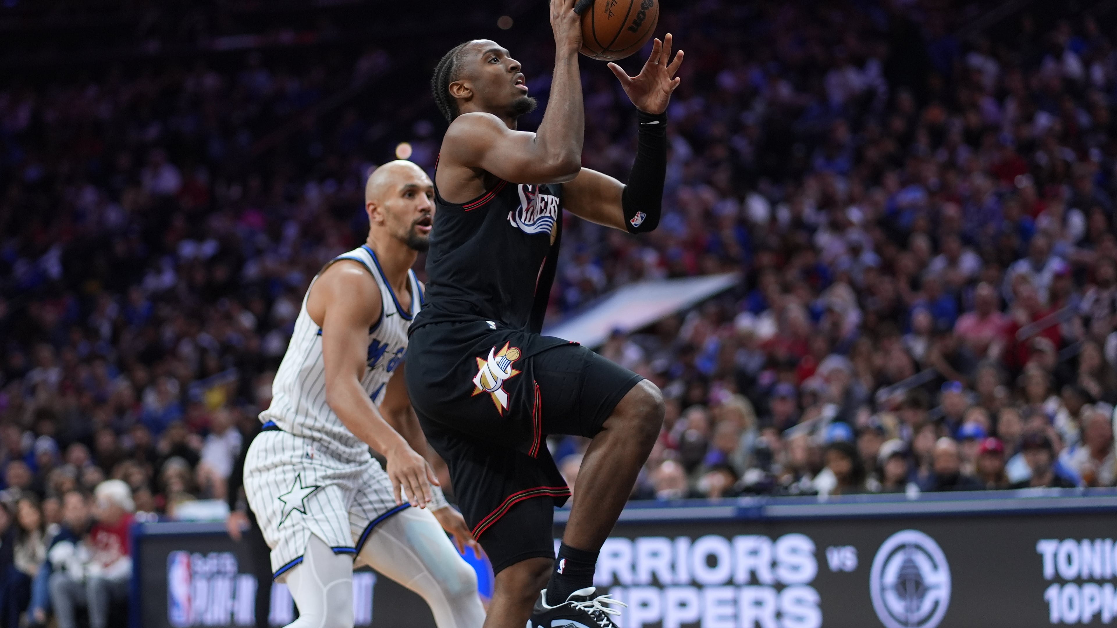 Philadelphia 76ers' Tyrese Maxey, right, goes up for a shot against Orlando Magic's Jalen Suggs during the second half of an NBA play-in tournament basketball game Wednesday, April 15, 2026, in Philadelphia. (AP Photo/Matt Slocum)