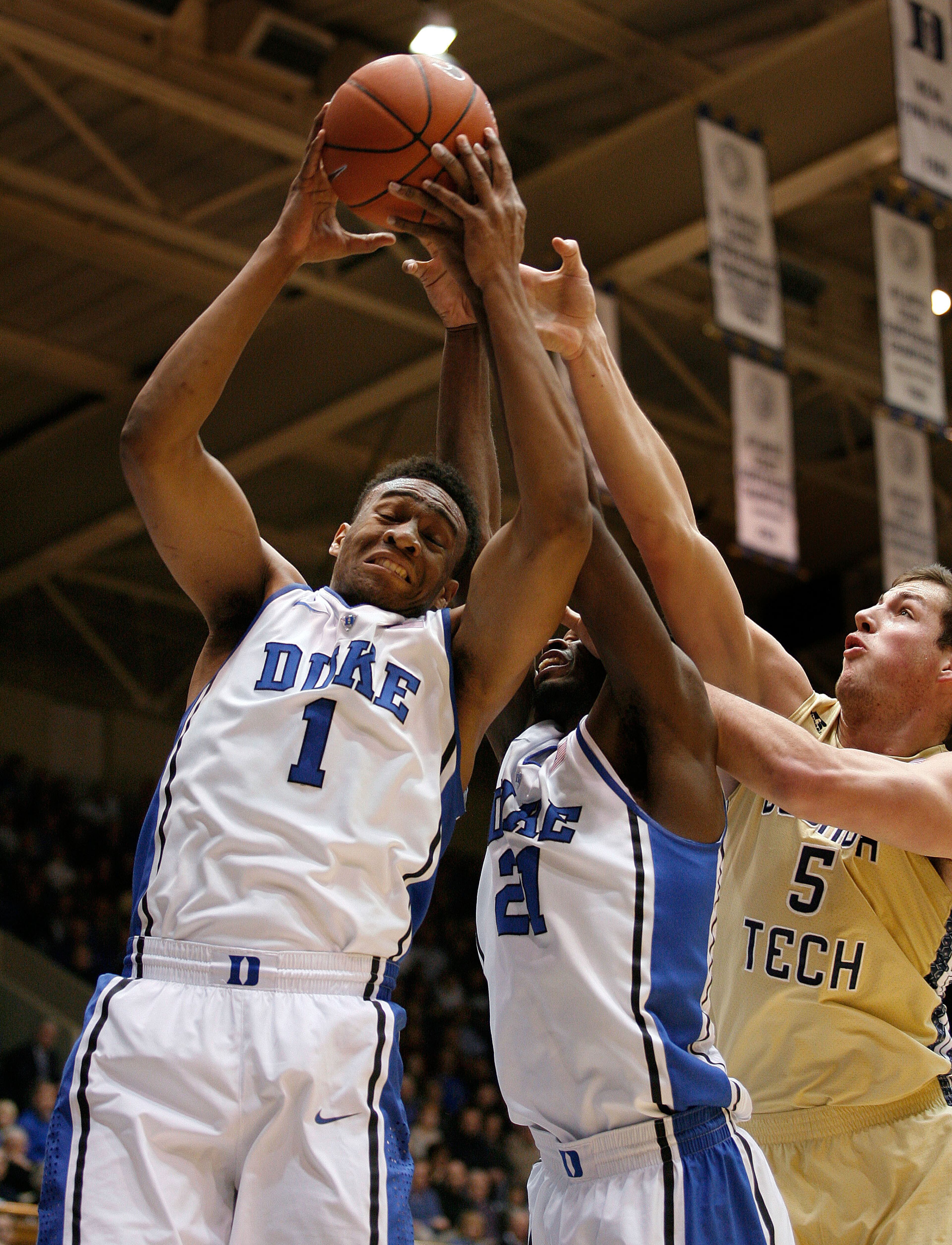 Duke Blue Devils forward Jabari Parker (1) pulls down a rebound against Georgia Tech Yellow Jackets center Daniel Miller (5) at Cameron Indoor Stadium.