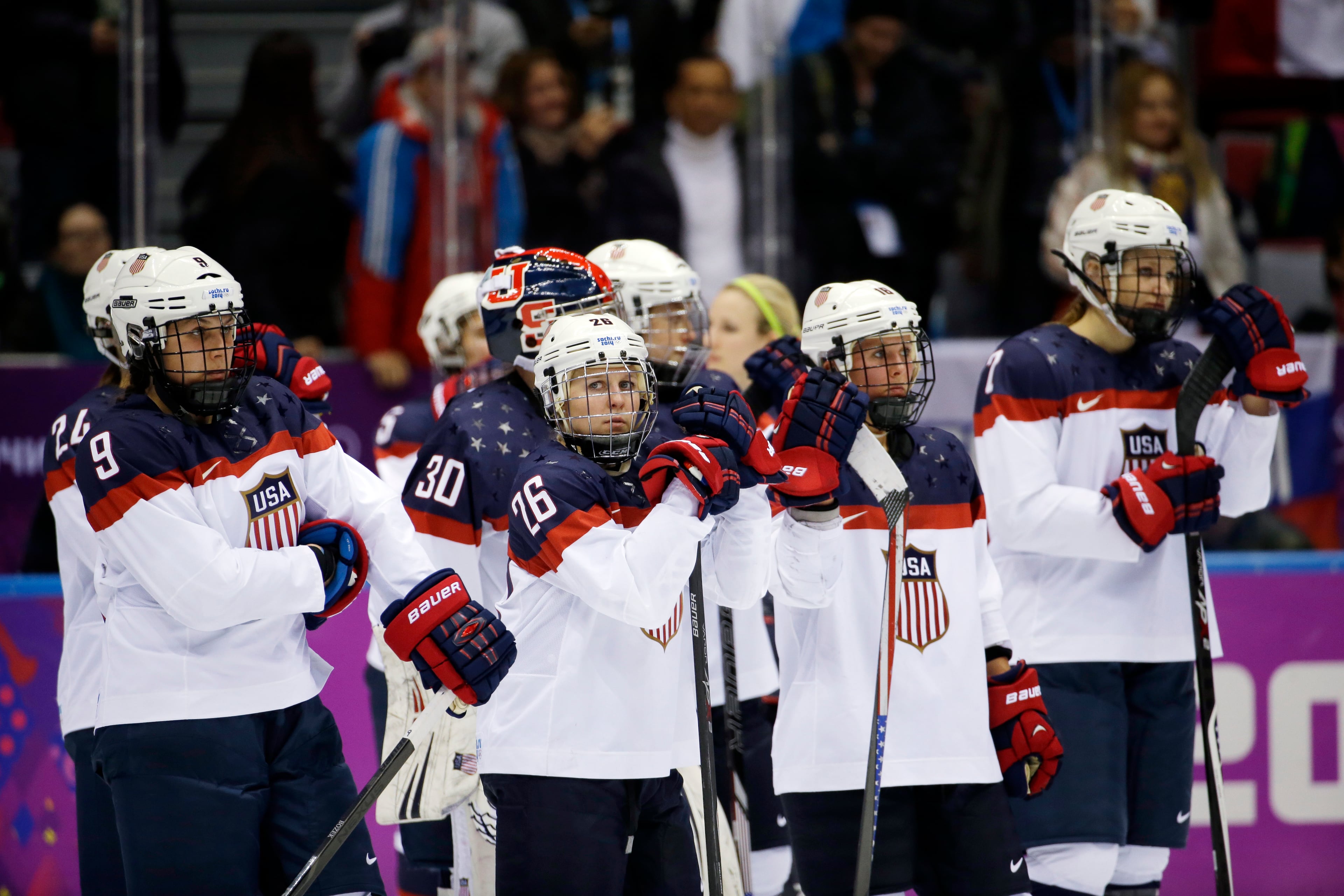 Members of team USA react after Canada won 3-2 in overtime of the gold medal women's ice hockey game at the 2014 Winter Olympics, Wednesday, Feb. 19, 2014, in Sochi, Russia. (AP Photo/David Goldman)