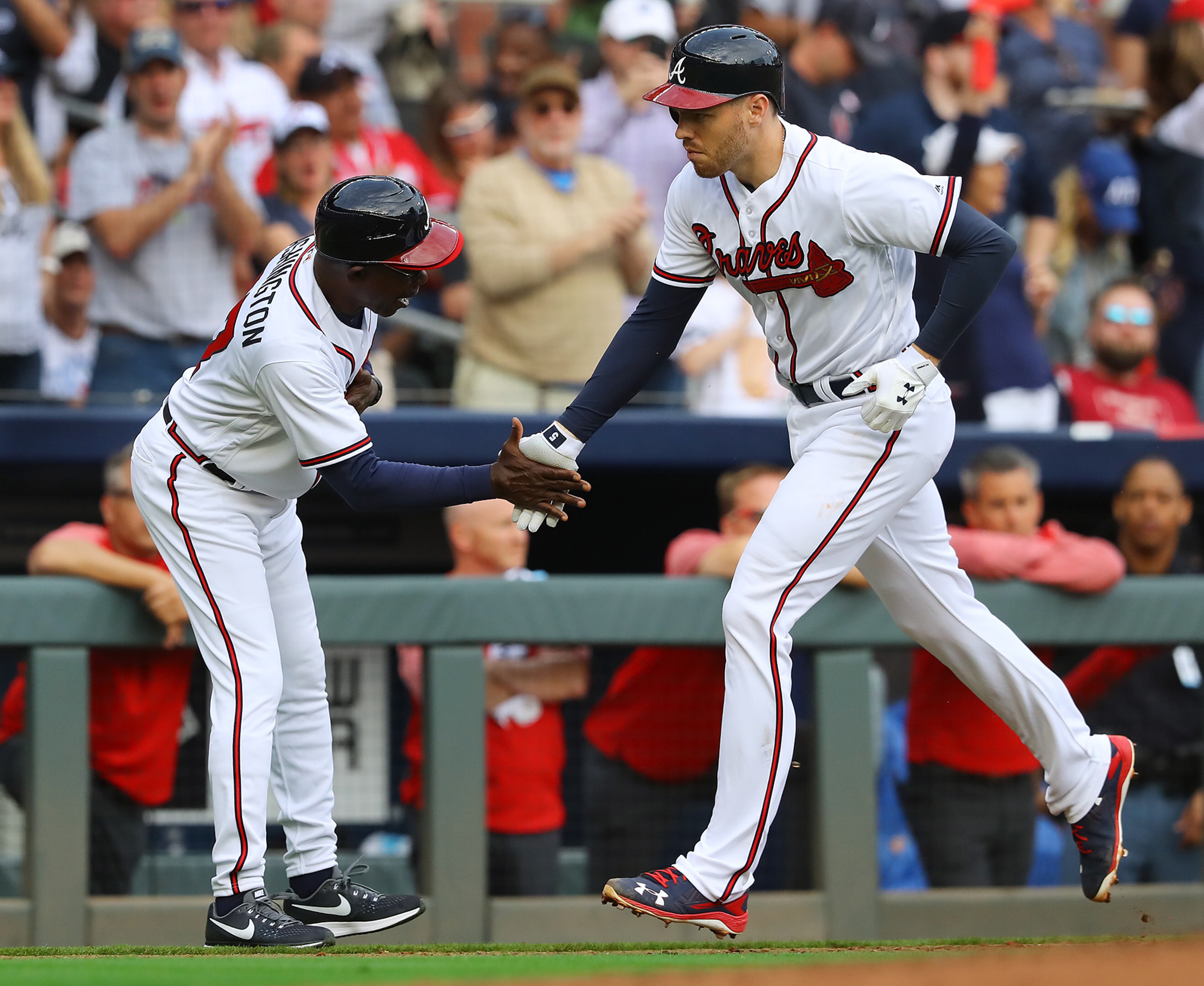 March 29, 2018 Atlanta: Atlanta Braves first baseman Freddie Freeman gets five from third base coach Ron Washington hitting a 2-run homer against the Phillies during the sixth inning in a MLB baseball home opening game on Thursday, March 29, 2018, in Atlanta. Curtis Compton/ccompton@ajc.com