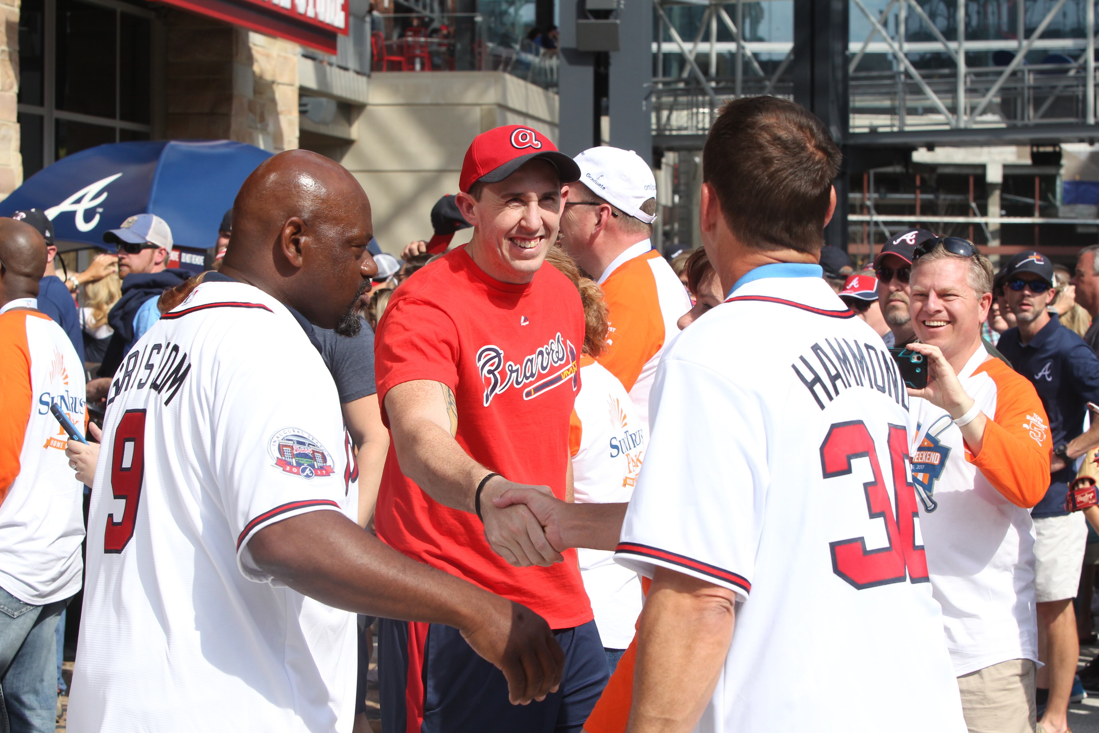 A fan shakes hands with former Atlanta Braves Chris Hammond (right) and Marquis Grissom (left) at the Atlanta Braves Opening Game at SunTrust Park in Cobb County.