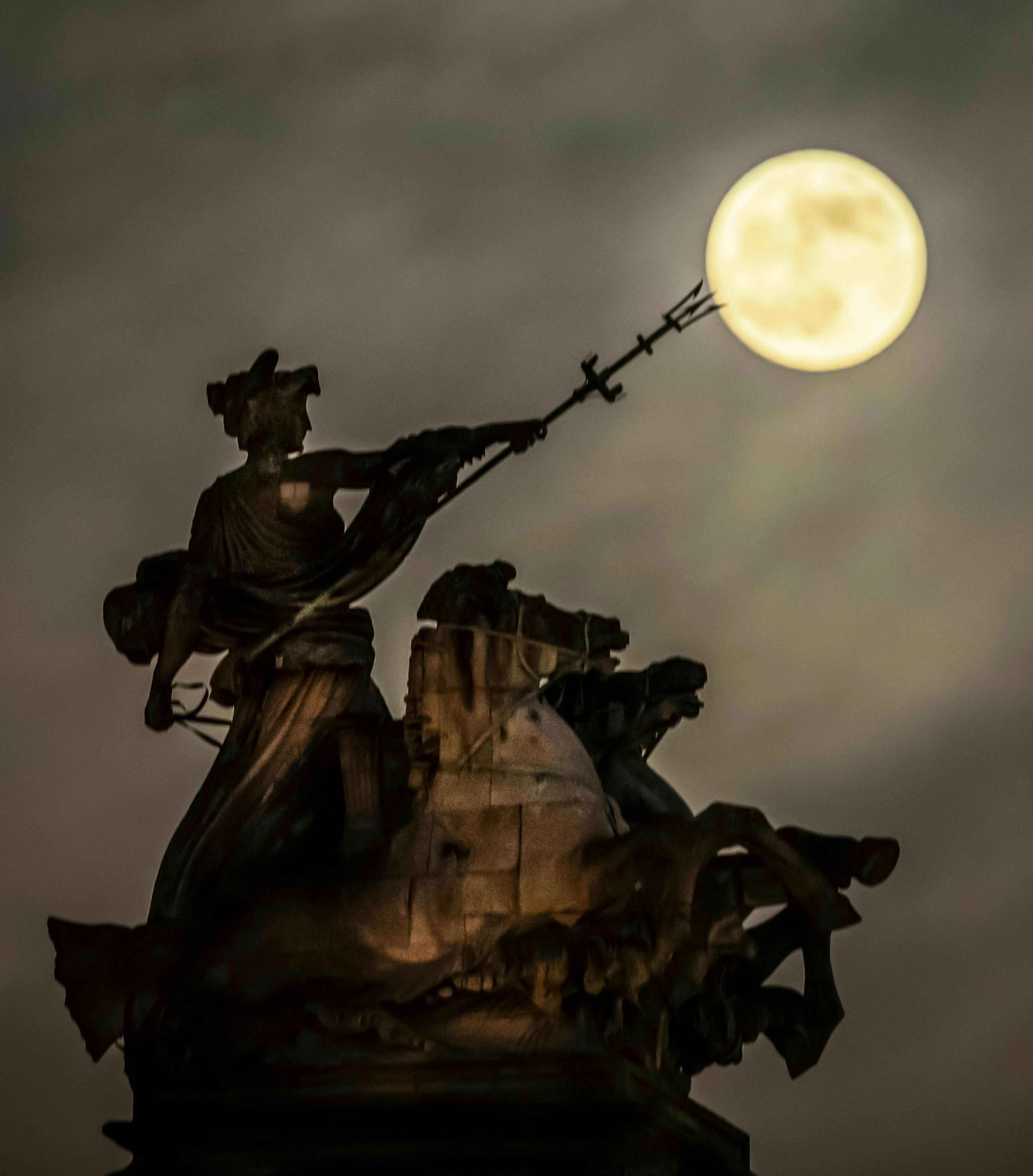 A blood moon, set to be the last of its kind for two years, rises above the 'Maritime Prowess' by Albert Hemstock Hodge on the Guild Hall ahead of the Lunar Eclipse, in Hull, England, Sunday, Jan. 20, 2019. (Danny Lawson/PA via AP)
