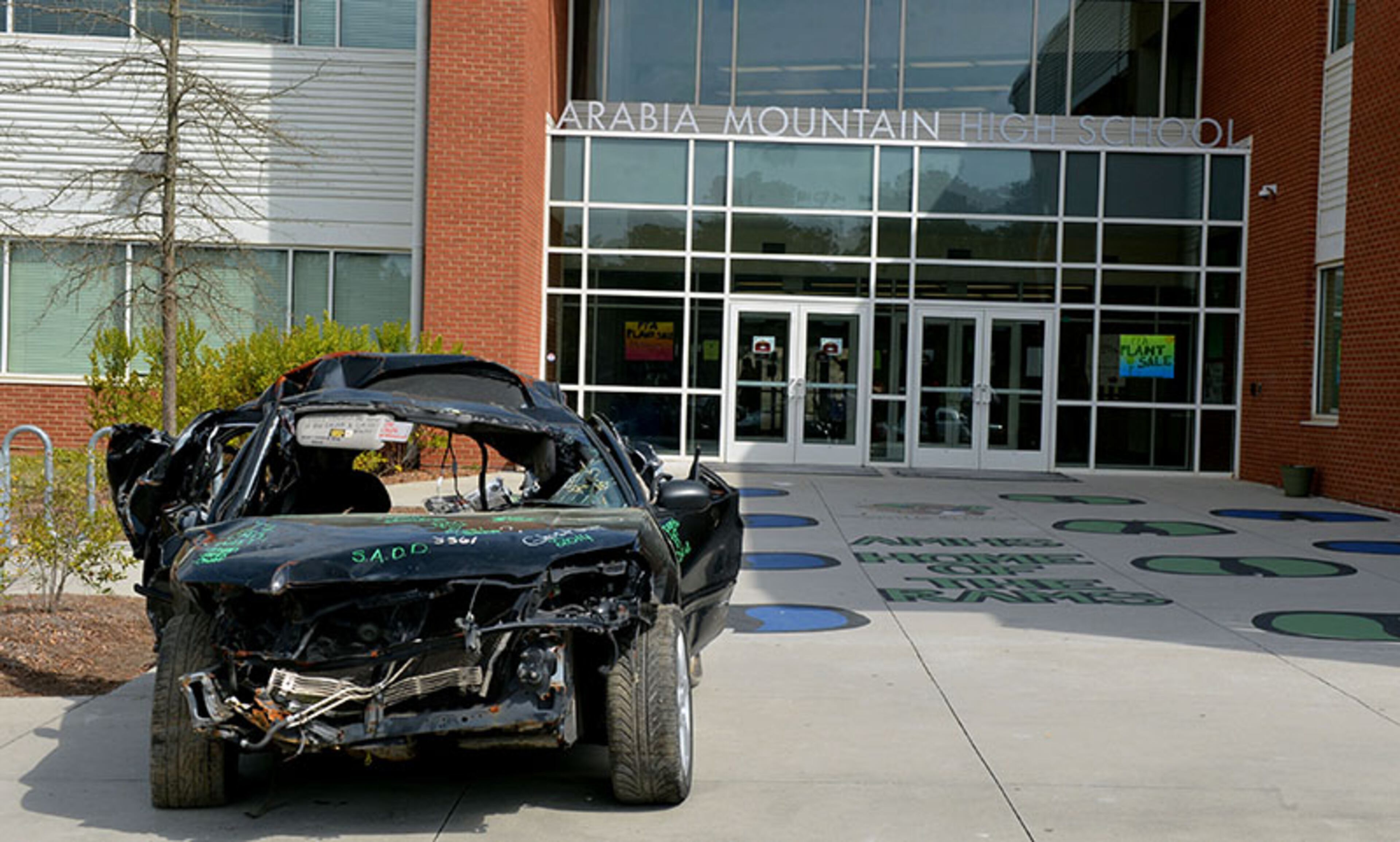A wrecked car sits outside the front entrance to Arabia Mountain High School Thursday, April 3, 2014.