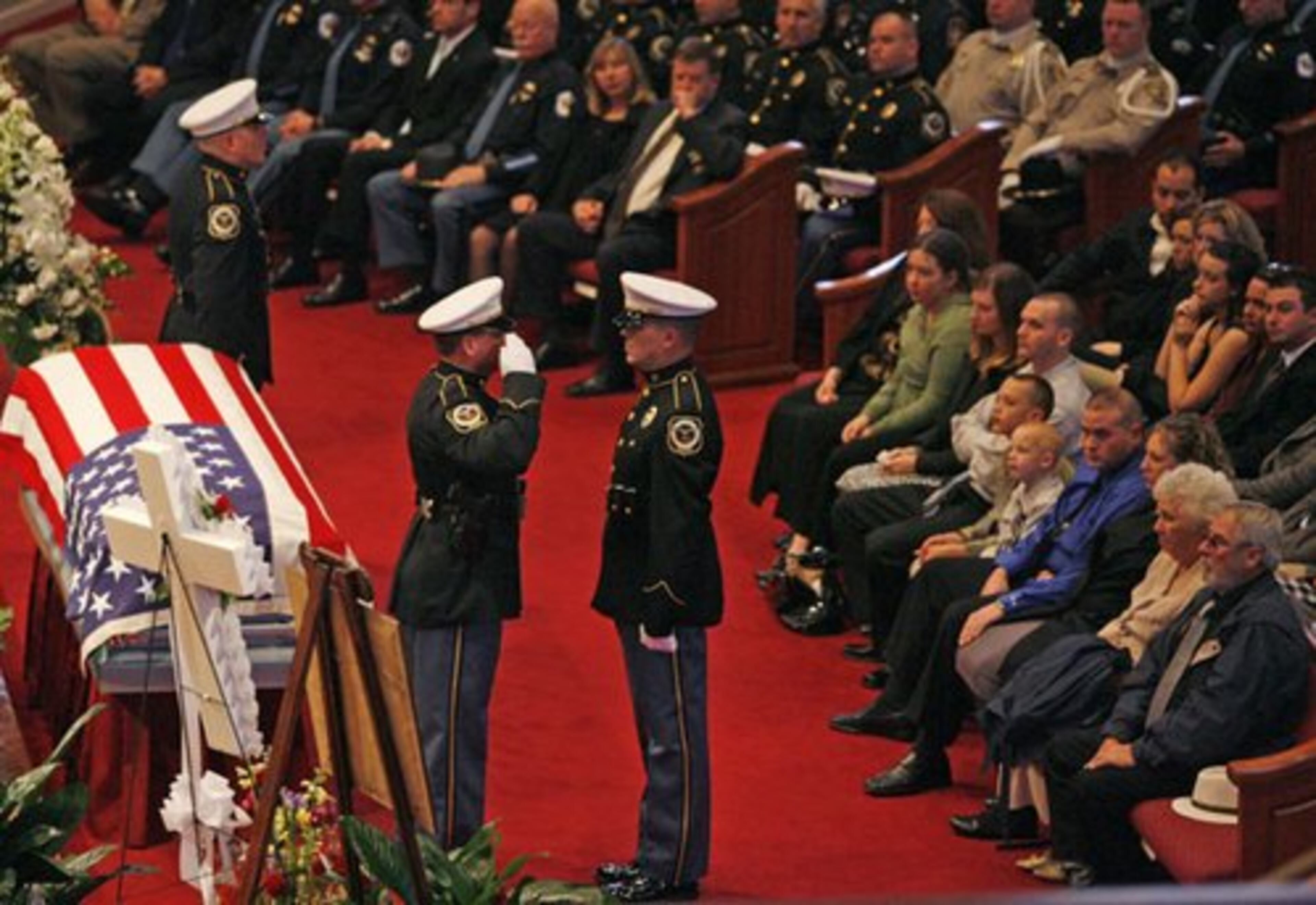 Cobb Police honor guard members salute during a changing of the guard during the service.