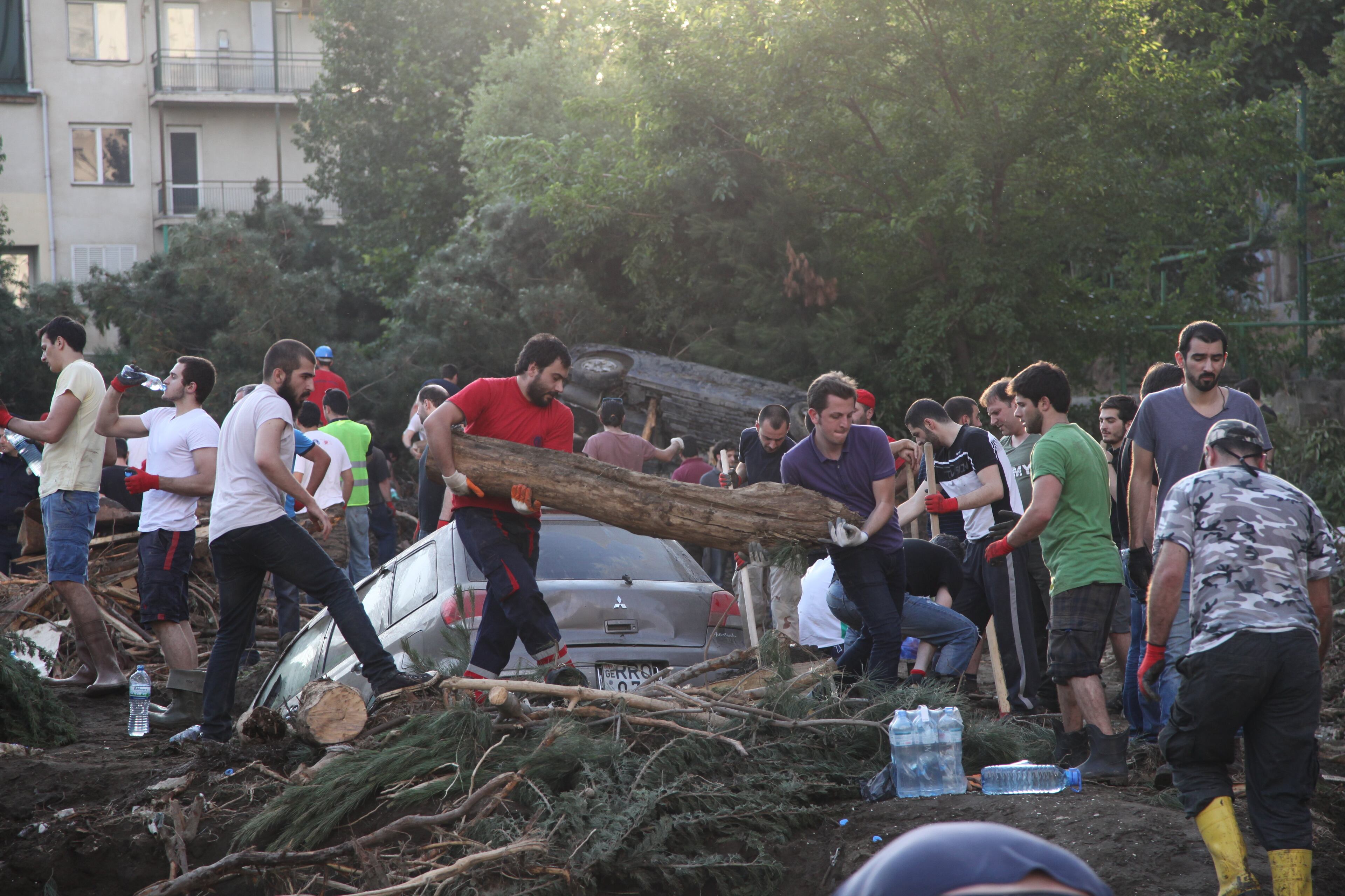 People clean a flooded area in Tbilisi, Georgia, Sunday, June 14, 2015. Severe flooding in the Georgian capital left at least 12 people dead Sunday and triggered a big-game hunt across the city for lions, tigers, a hippopotamus and other dangerous animals that escaped from Tbilisi's ravaged zoo. (AP Photo/Tinatin Kiguradze)