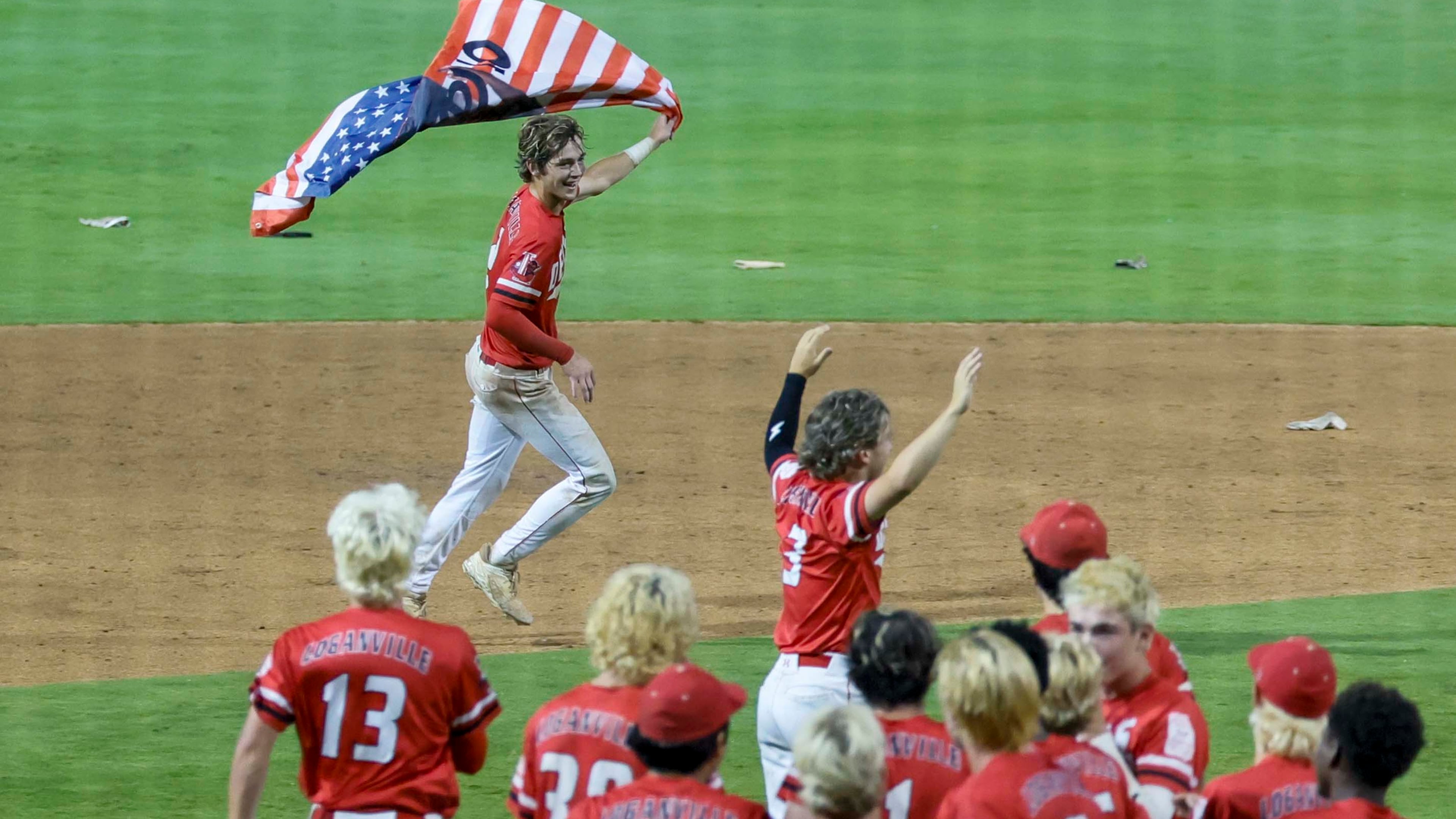Loganville’s Brantley Carter (2) runs with an American flag after hitting a walk-off single to win the game 4-3 against Pope in Game 3 of the Class 5A GHSA Baseball State Championship Series at Gwinnett Field on Tuesday, May 26, 2026, in Lawrenceville, Ga. Loganville won the series 2-1.(Miguel Martinez/AJC)