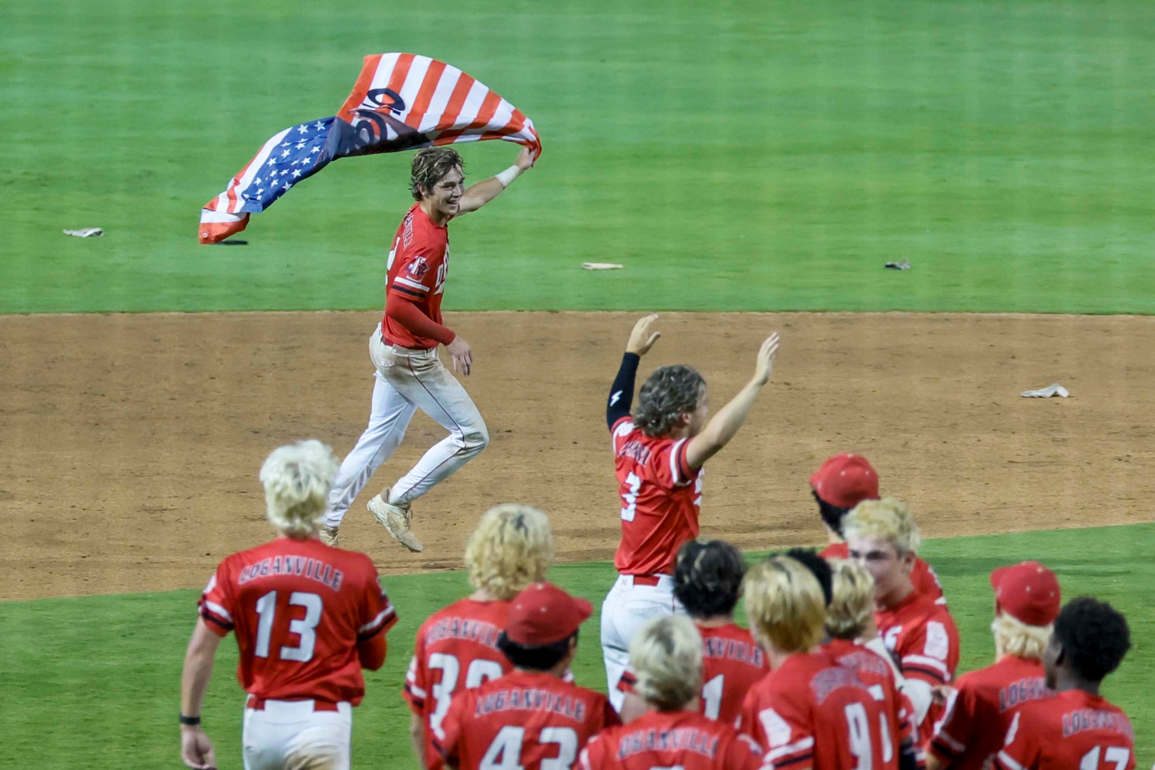 Loganville’s Brantley Carter (2) runs with an American flag after hitting a walk-off to win the game 4-3 against Pope in Game 3 of the Class 5A GHSA Baseball State Championship Series at Gwinnett Field on Tuesday, May 26, 2026, in Lawrenceville, Ga. Loganville won the series 4-3. (Miguel Martinez/AJC)