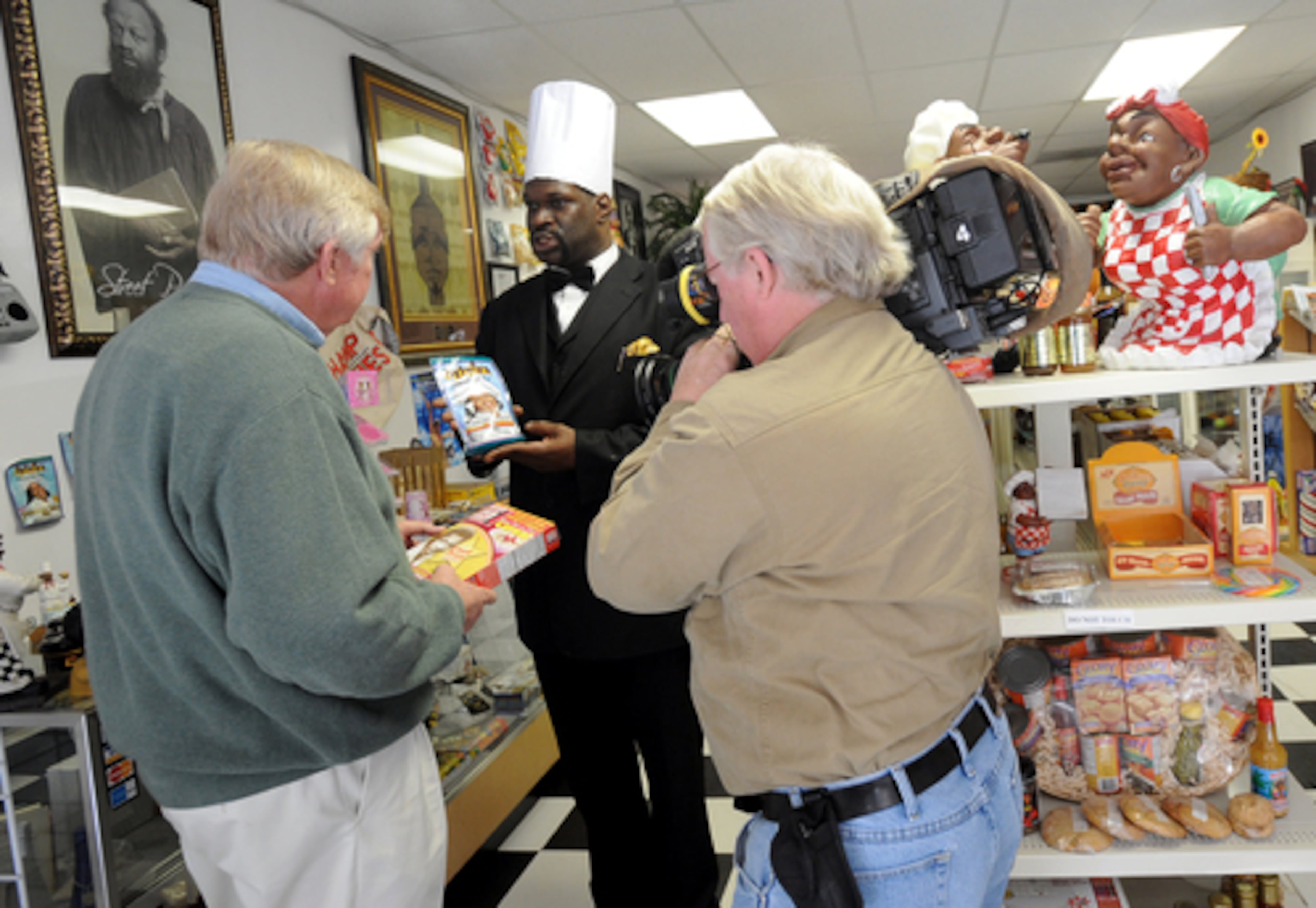 Richard Crabbe (right) records WXIA-TV anchor Wes Sarginson (left) as he interviews Kenneth Willhoite about the financial plight of the chef's Soul Food Museum in Atlanta in 2008. (Hyosub Shin/AJC 2008