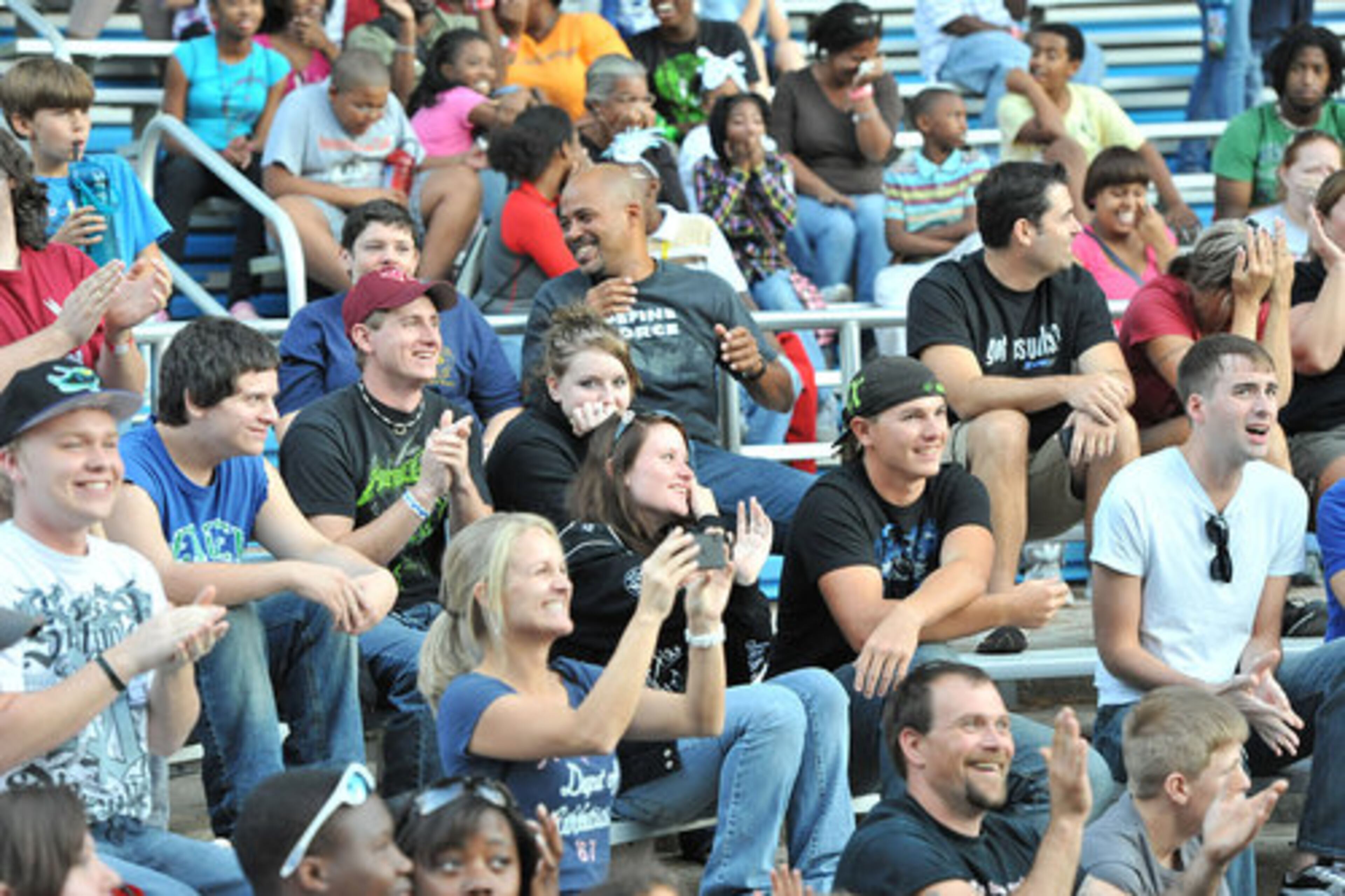 The crowd cheers as contestants try to eat insects.