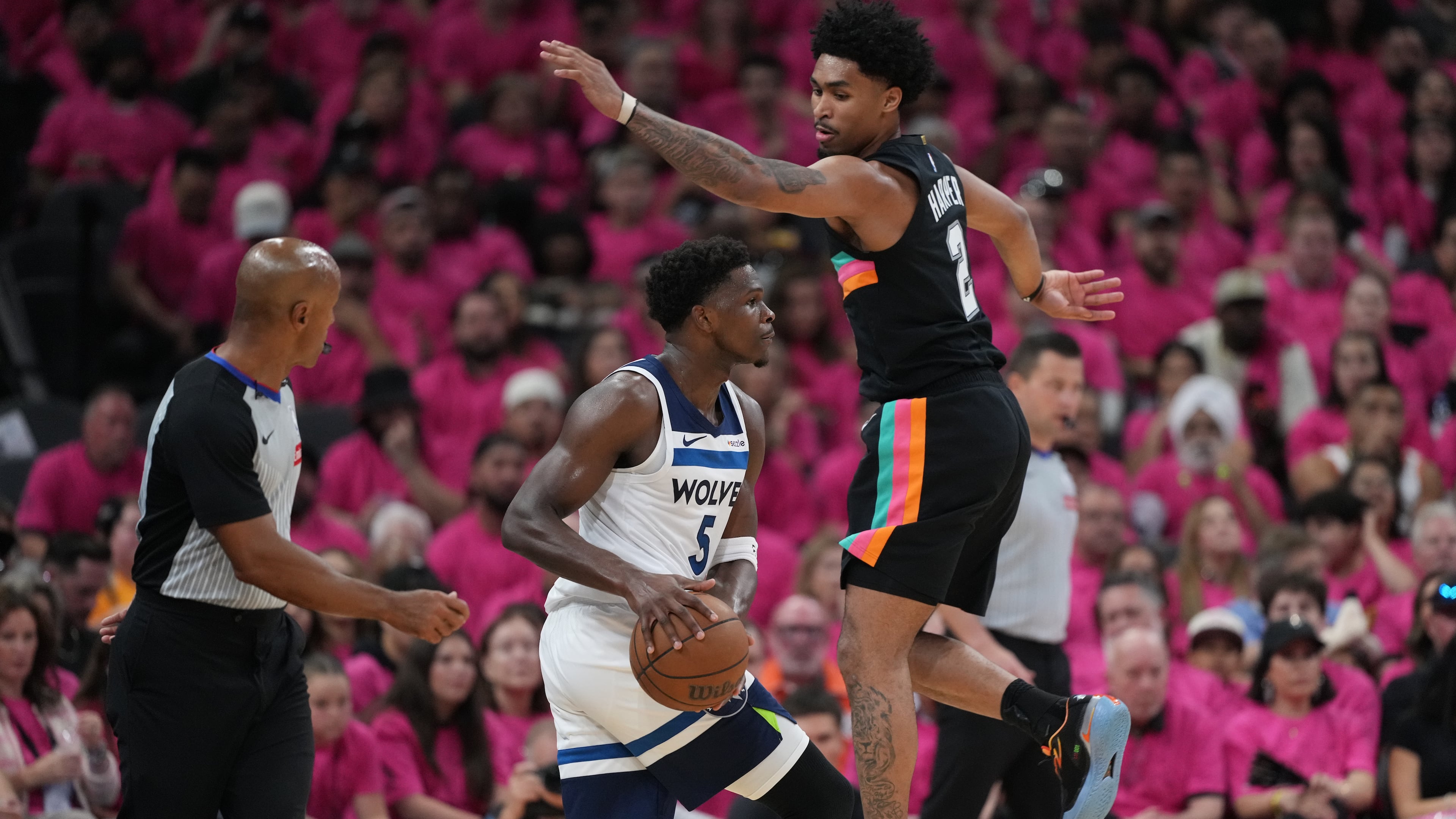 Minnesota Timberwolves guard Anthony Edwards (5) handles the ball as San Antonio Spurs guard Dylan Harper (2) defends during the first half in Game 1 of a second-round NBA playoffs basketball series in San Antonio, Monday, May 4, 2026. (AP Photo/Eric Gay)