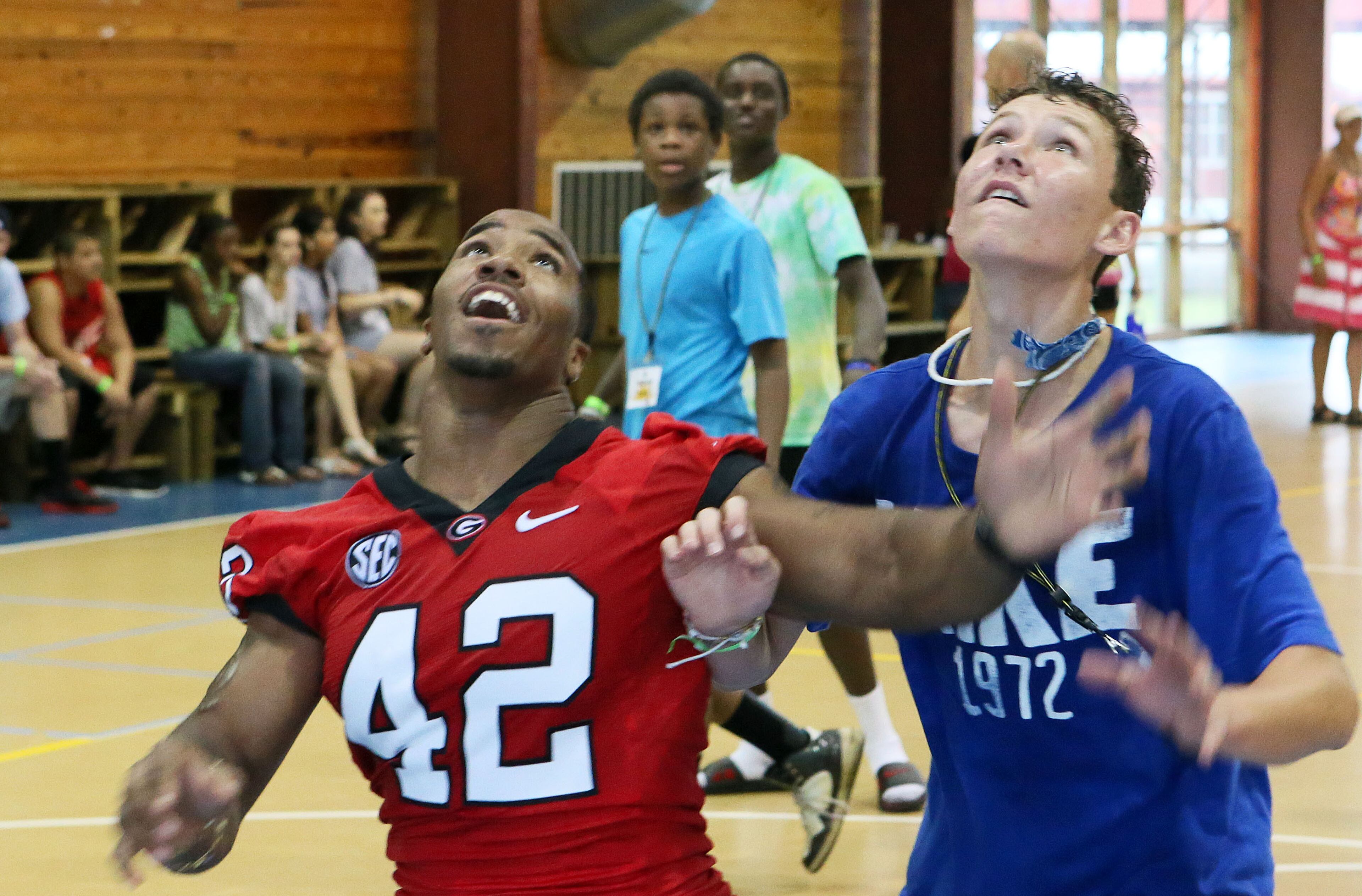 UGA football player Corey Campbell (left) and Camp Sunshine attendee Luke Lawson play basketball.