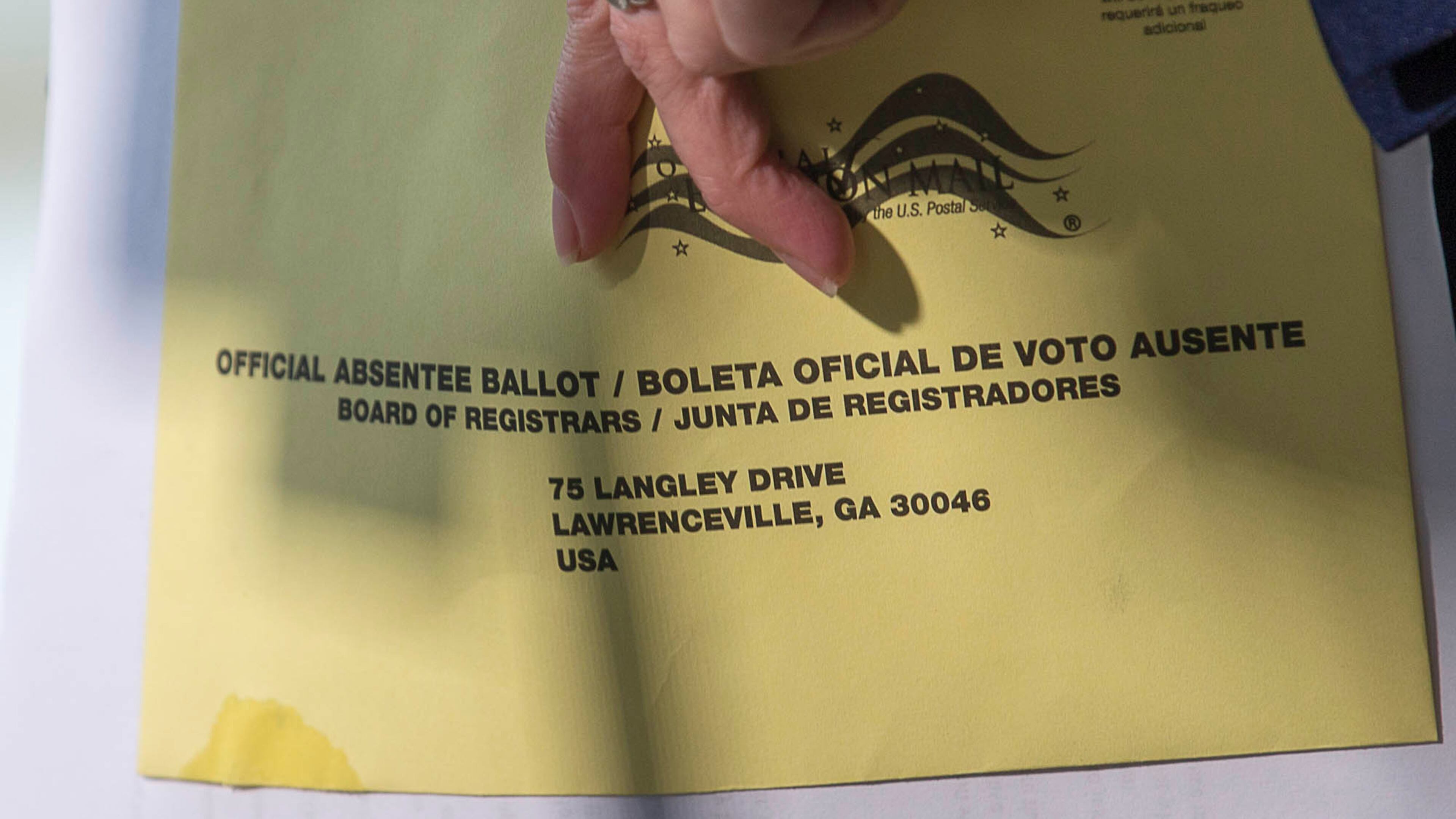 Carolyn Bourdeaux, Democratic Nominee for Georgia's 7th Congressional District, holds onto a Gwinnett County absentee ballot as she speaks during a press conference outside of the Gwinnett County Board of Voter Registration and Elections in Lawrenceville on Nov. 12, 2018. (ALYSSA POINTER/ALYSSA.POINTER@AJC.COM)