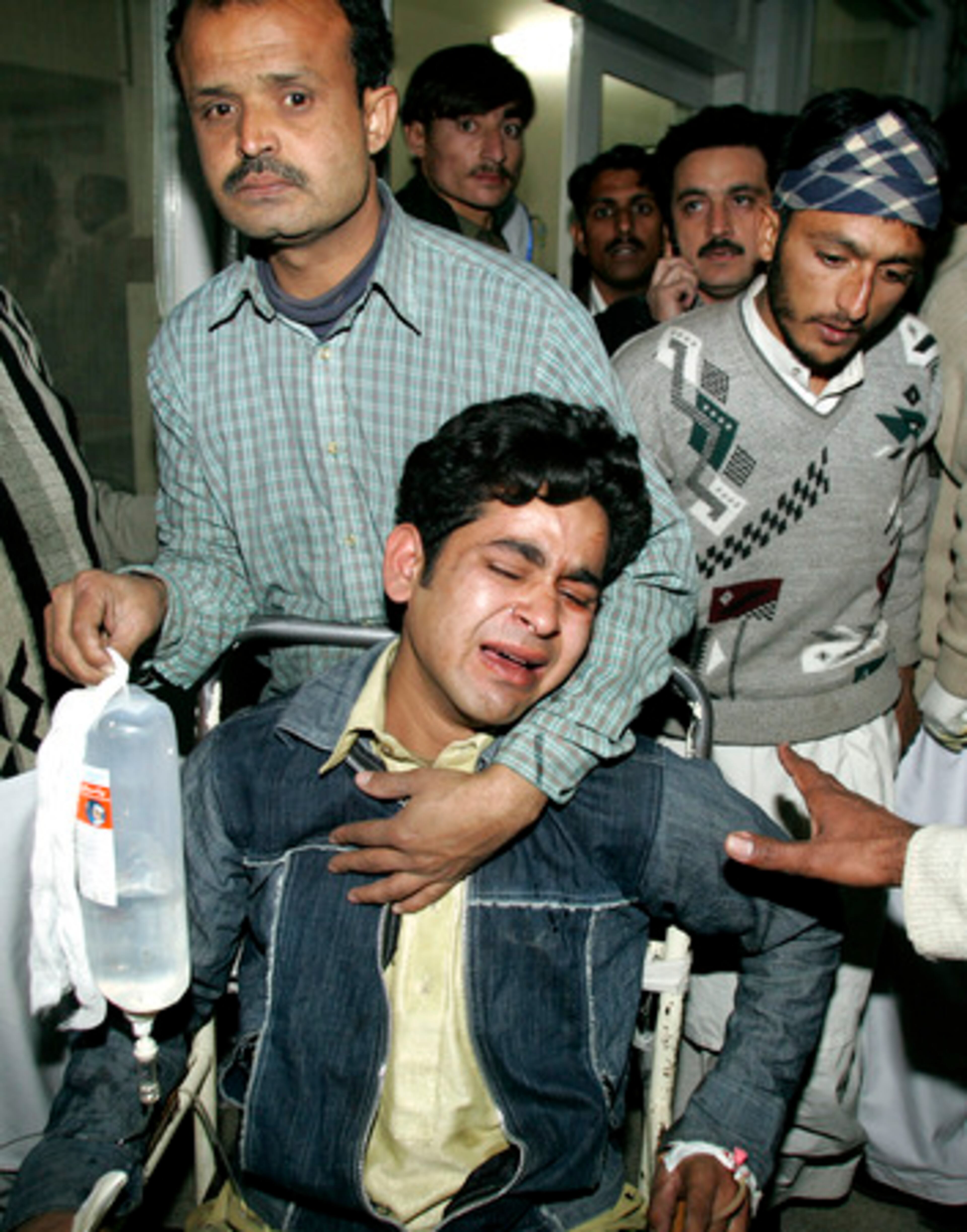 An injured victim of suicide attack is comforted by a relative at the local hospital in Rawalpindi.