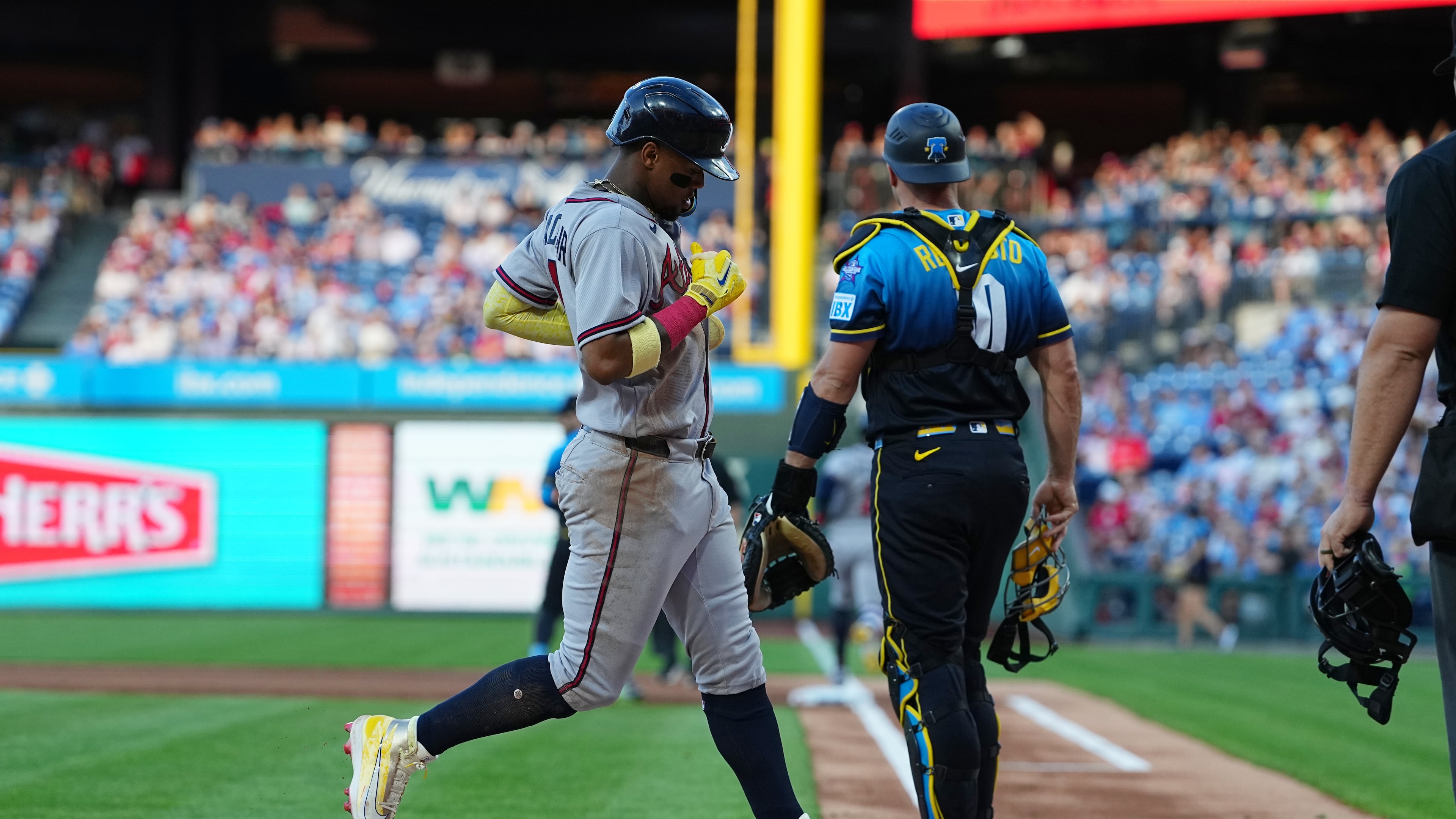 Atlanta Braves' Ronald Acuña Jr. scores past Philadelphia Phillies catcher J.T. Realmuto off of a hit by teammate Ozzie Albies during the first inning of a baseball game, Friday, April 17, 2026, in Philadelphia. (AP Photo/Matt Rourke)