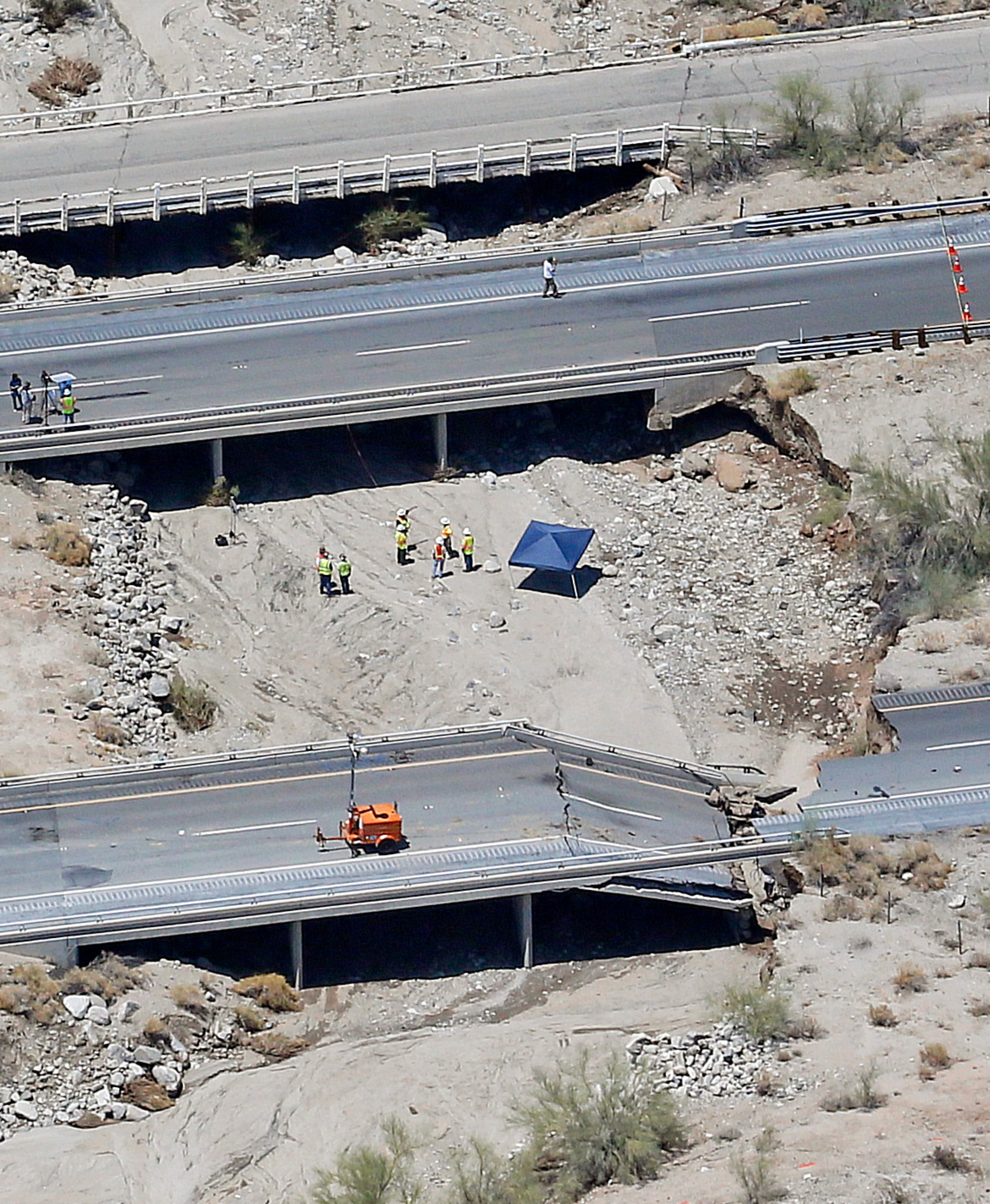 This aerial photo shows the collapsed elevated section of Interstate 10, Monday, July 20, 2015, in Desert Center, Calif. All traffic along one of the major highways connecting California and Arizona was blocked indefinitely when the bridge over a desert wash collapsed during a major storm, and the roadway in the opposite direction sustained severe damage. (AP Photo/Matt York)