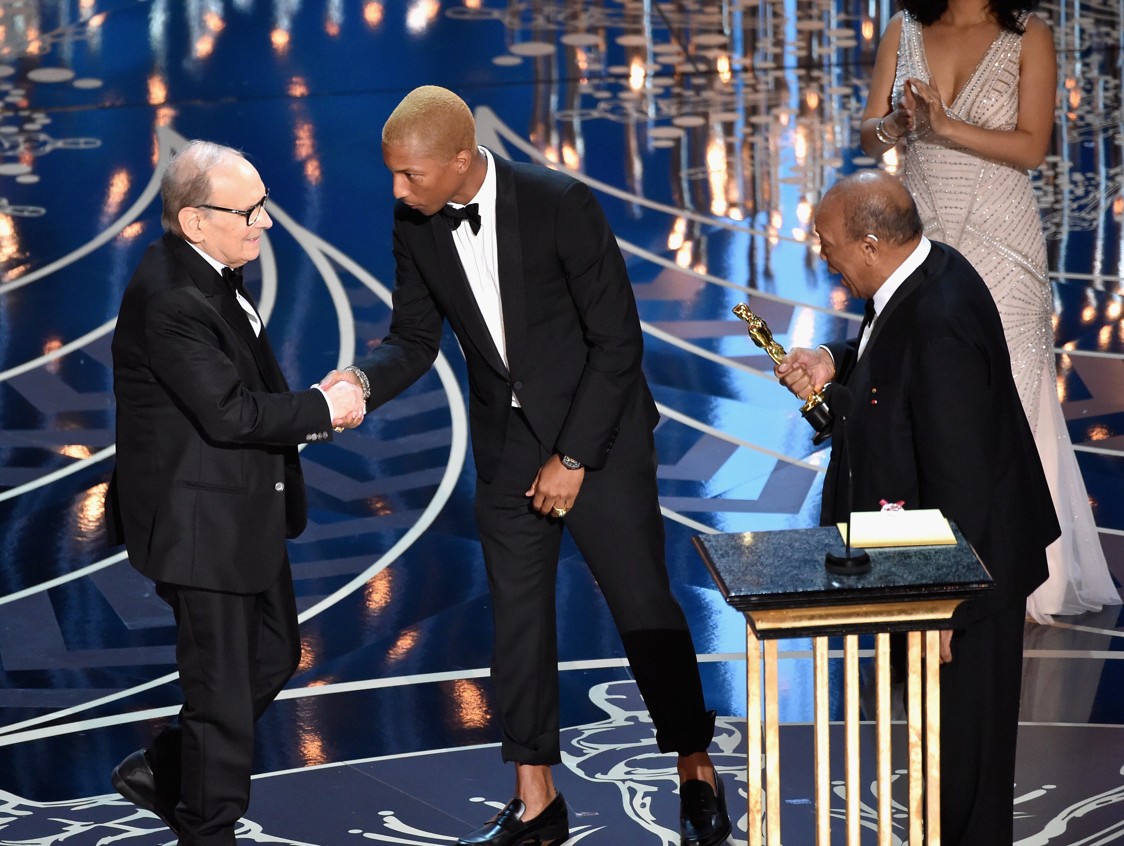 HOLLYWOOD, CA - FEBRUARY 28: (L-R) Composer Ennio Morricone accepts the Best Original Score award for ''The Hateful Eight' from musicians Pharrell Williams and Quincy Jones onstage during the 88th Annual Academy Awards at the Dolby Theatre on February 28, 2016 in Hollywood, California. (Photo by Kevin Winter/Getty Images)