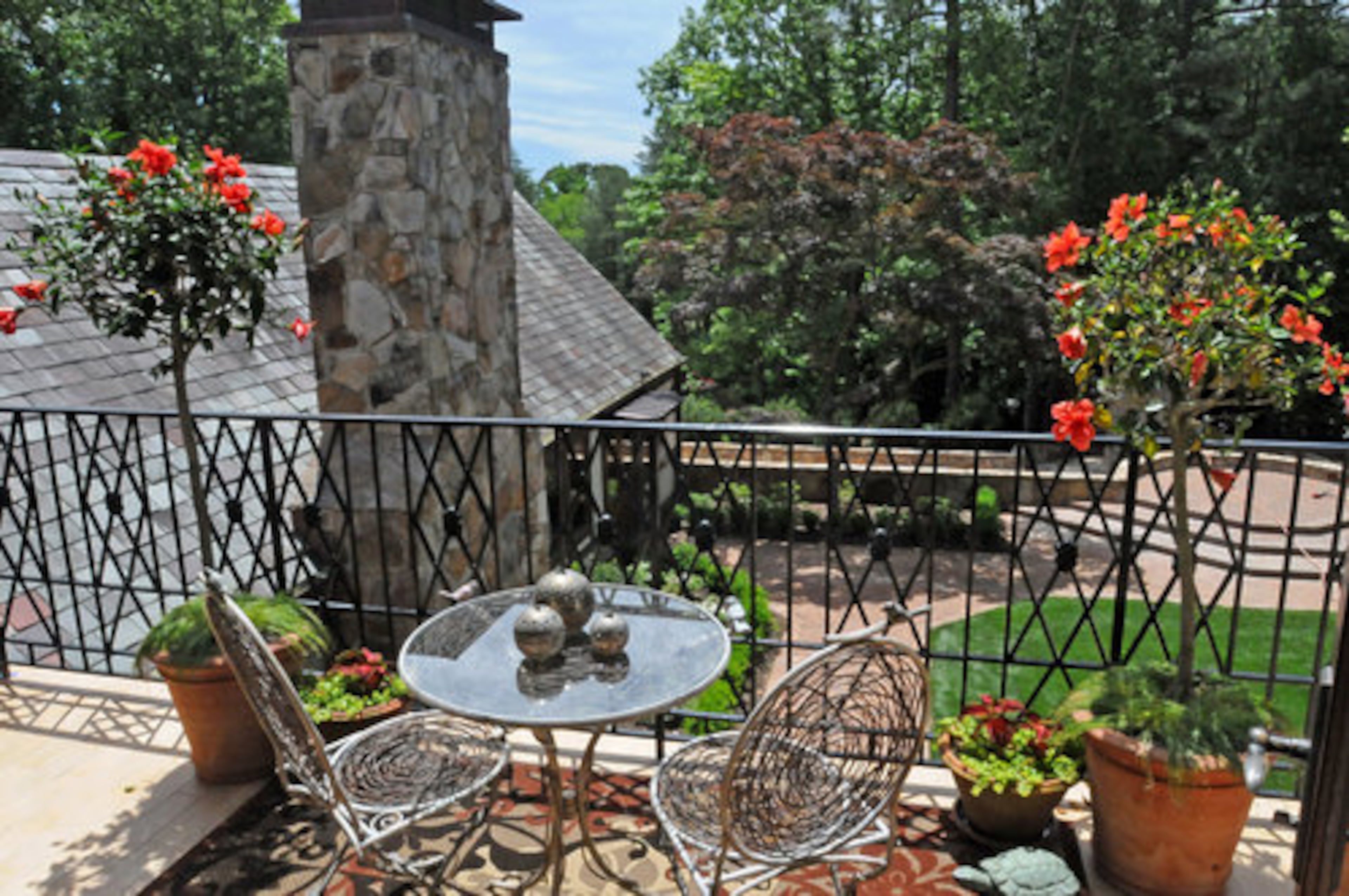 Edward Holifield of Edward Holifield by Design brightened up this balcony seating area by adding plants for a touch of greenery.