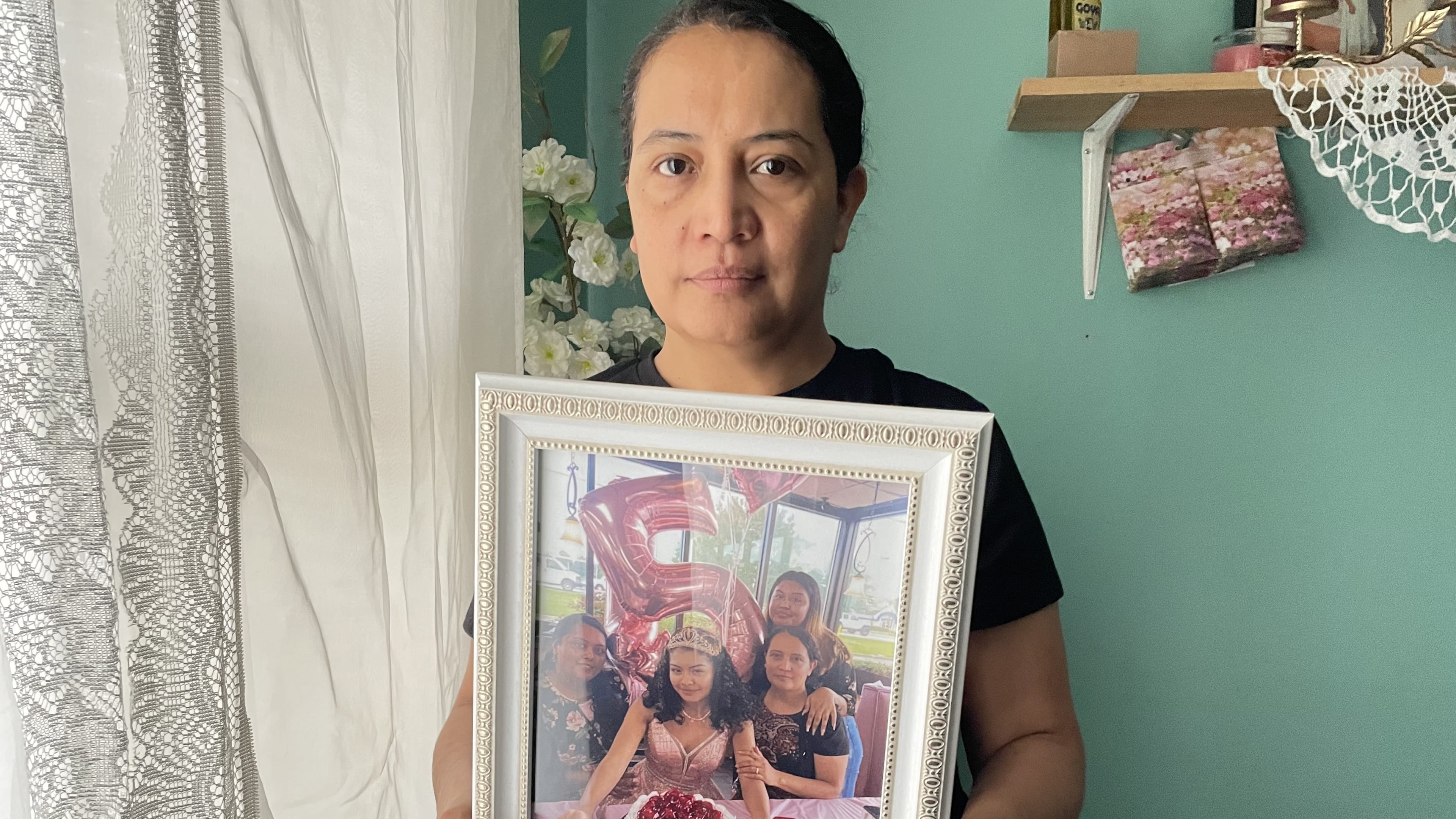 Maria Bran holds a photo of her daughter Susana Morales, whose body was found recently in Gwinnett County. A former Doraville police officer has been arrested in connection with her death.
