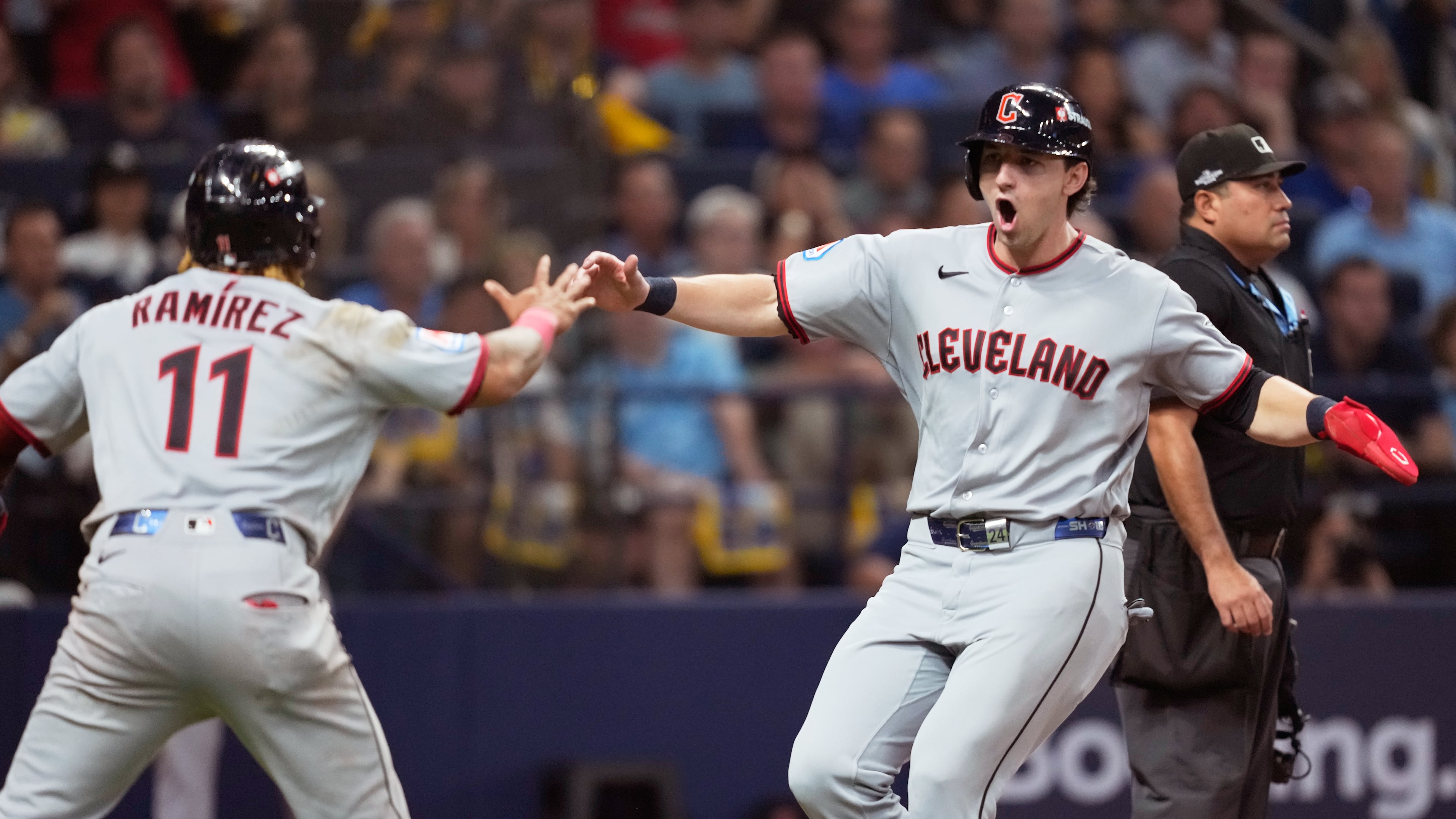 Cleveland Guardians' José Ramírez and Chase DeLauter celebrate after scoring on a single by Nathaniel Lowe against the Tampa Bay Rays during the eighth inning in Game 1 of an American League Championship Series baseball game in St. Petersburg, Fla. Monday, Oct. 12, 2026. (AP Photo/David J. Phillip)