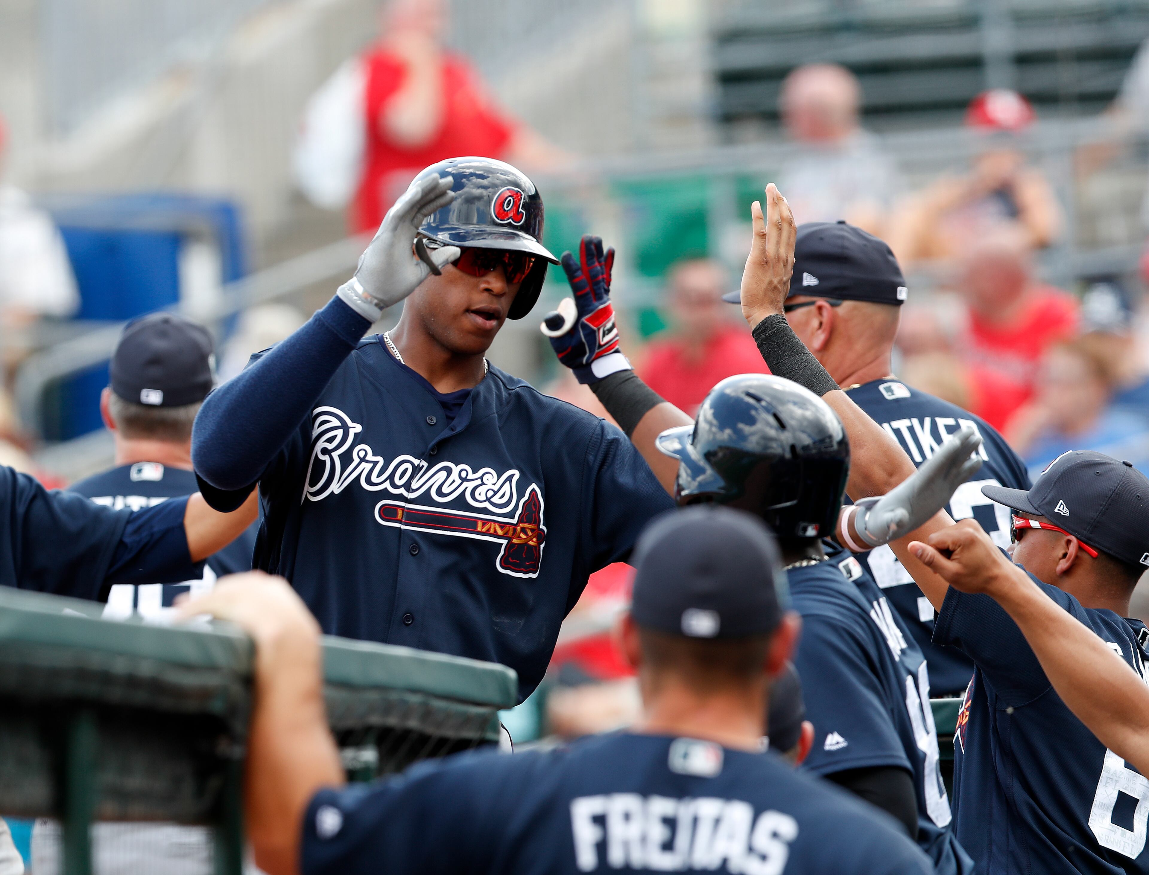 Atlanta Braves' Adam Walker is greeted at the dugout by teammates after hitting a home run in the first inning of a spring training baseball game against the St. Louis Cardinals Thursday, March 2, 2017, in Jupiter, Fla. (AP Photo/John Bazemore)