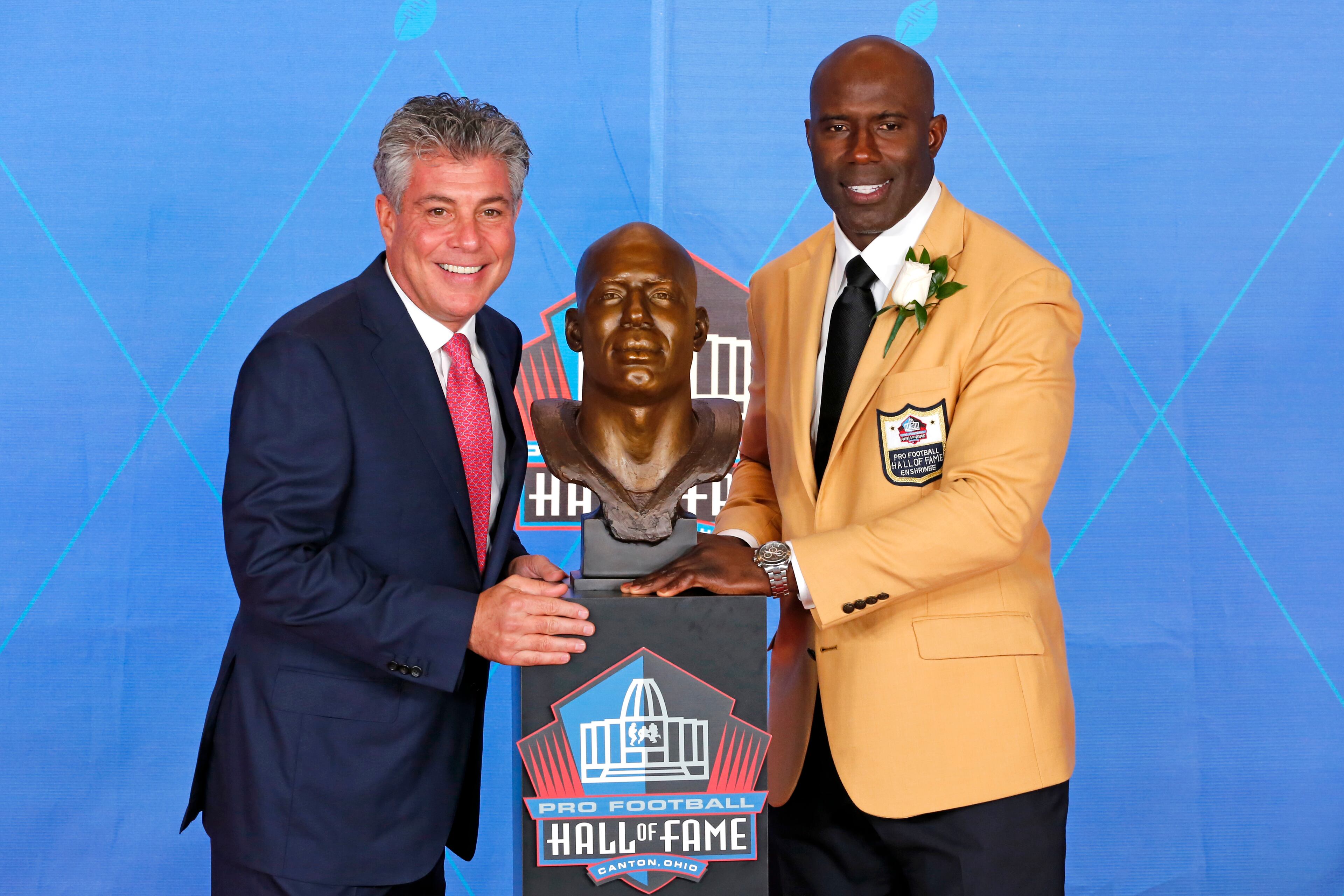 Terrell Davis, right, poses with his bust and with presenter and agent Neil Schwartz, during inductions at the Pro Football Hall of Fame, Saturday, Aug. 5, 2017, in Canton, Ohio. (AP Photo/Gene J. Puskar)