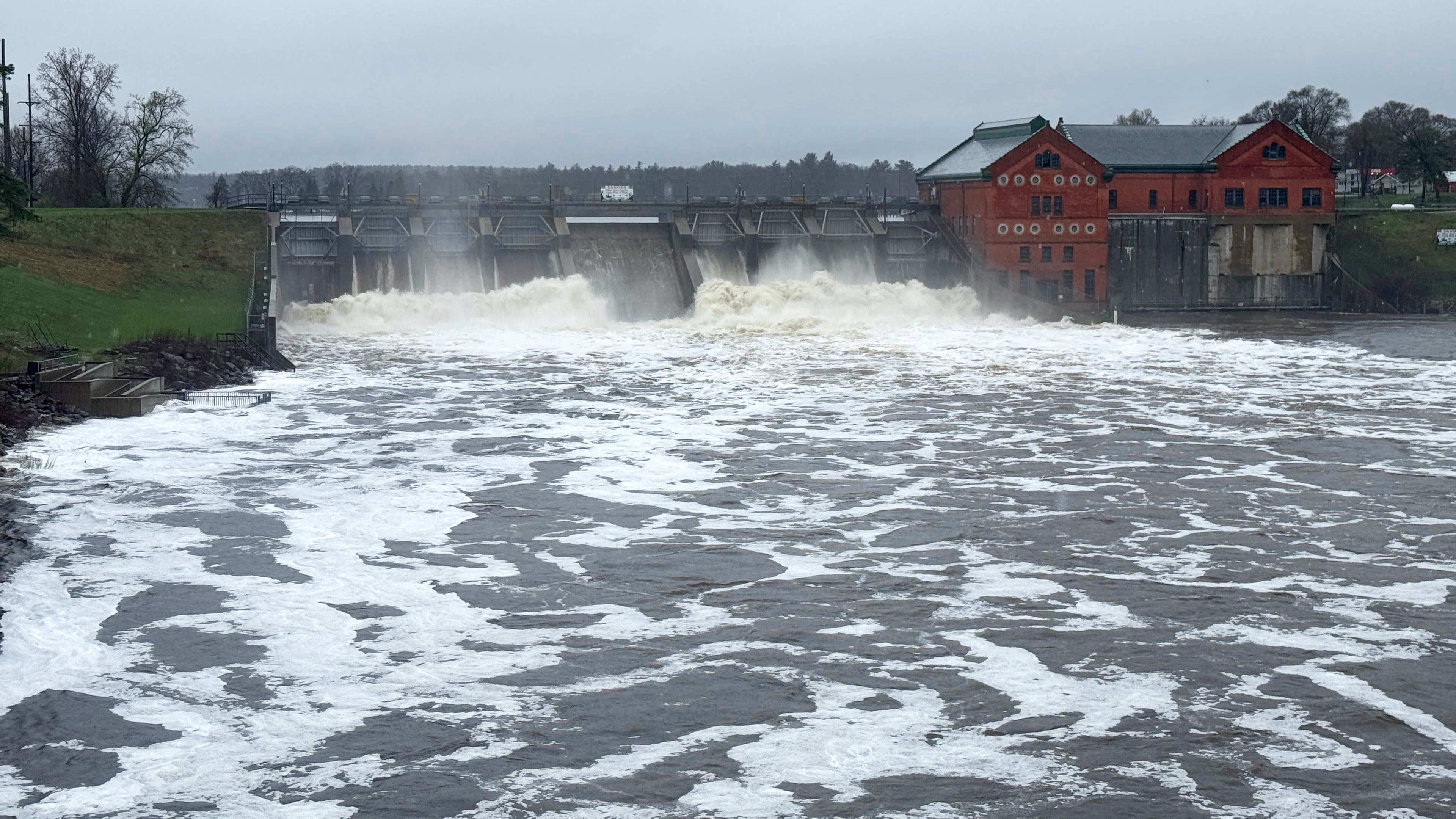 This photo provided by Bruce Carlson shows water rushing through the Croton Dam on Thursday, April 16, 2026, in Croton Township, Mich. (Bruce Carlson via AP)