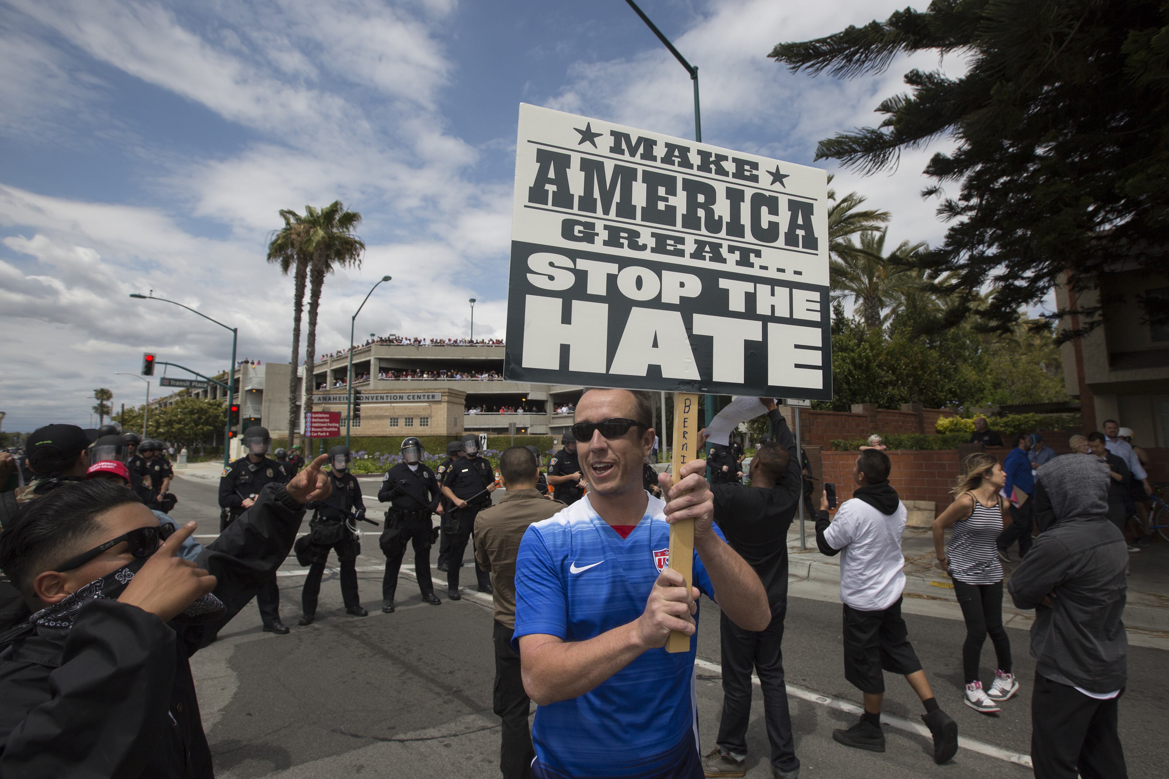 ANAHEIM, CA - MAY 25: Police force protesters down a street, away from Trump supporters jeering from a parking structure, near a campaign rally by presumptive GOP presidential candidate Donald Trump at the Anaheim Convention Center on May 25, 2016 in Anaheim, California. Previous visits by the candidate to Orange County have sparked in protests that resulted in some arrests. The presidential candidates are campaigning in Southern California for the June 7 California primary. (Photo by David McNew/Getty Images)