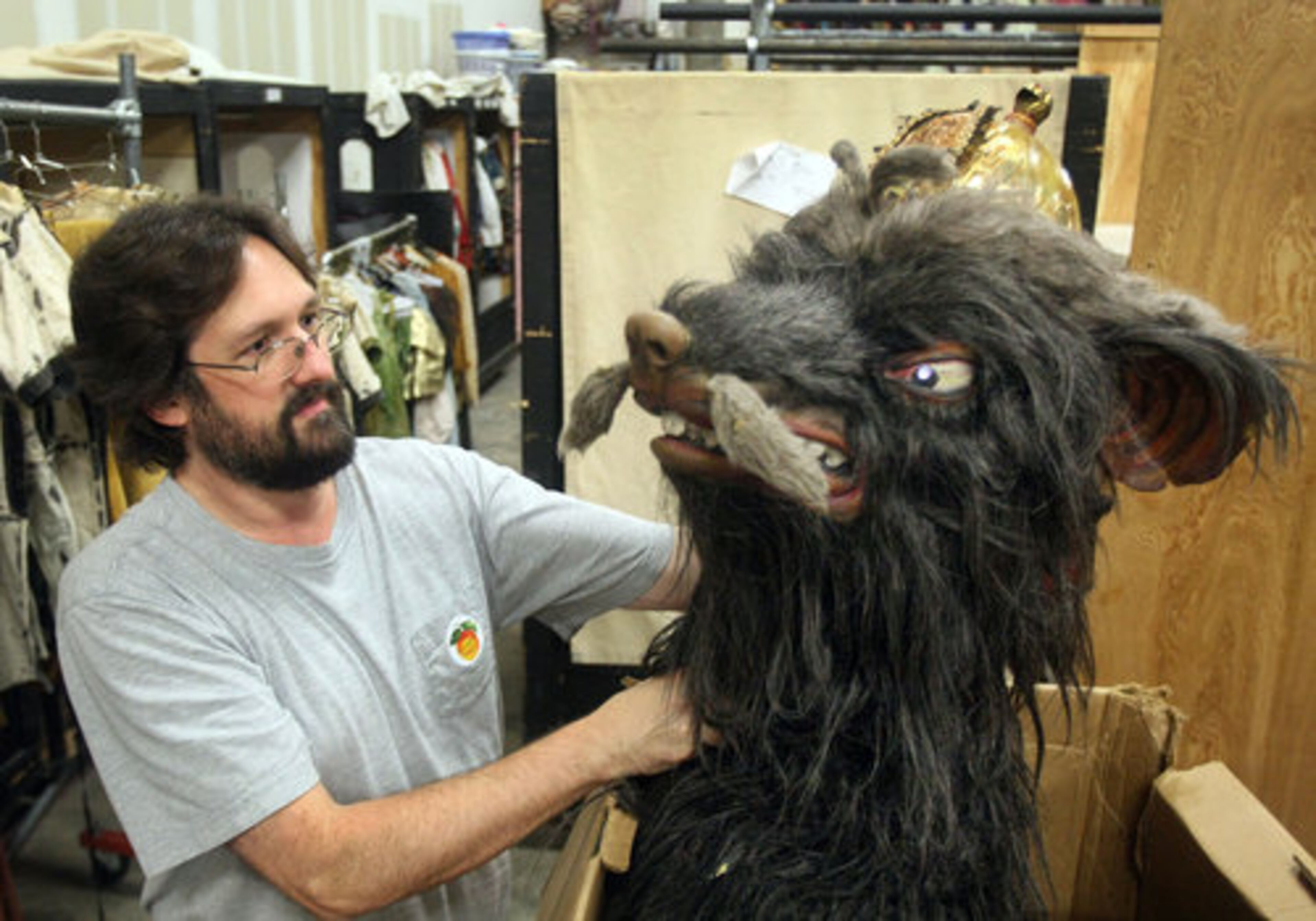 Facilities manager David Tatu looks at the Rat King's head from "The Nutcracker" in the wardrobe storage room.