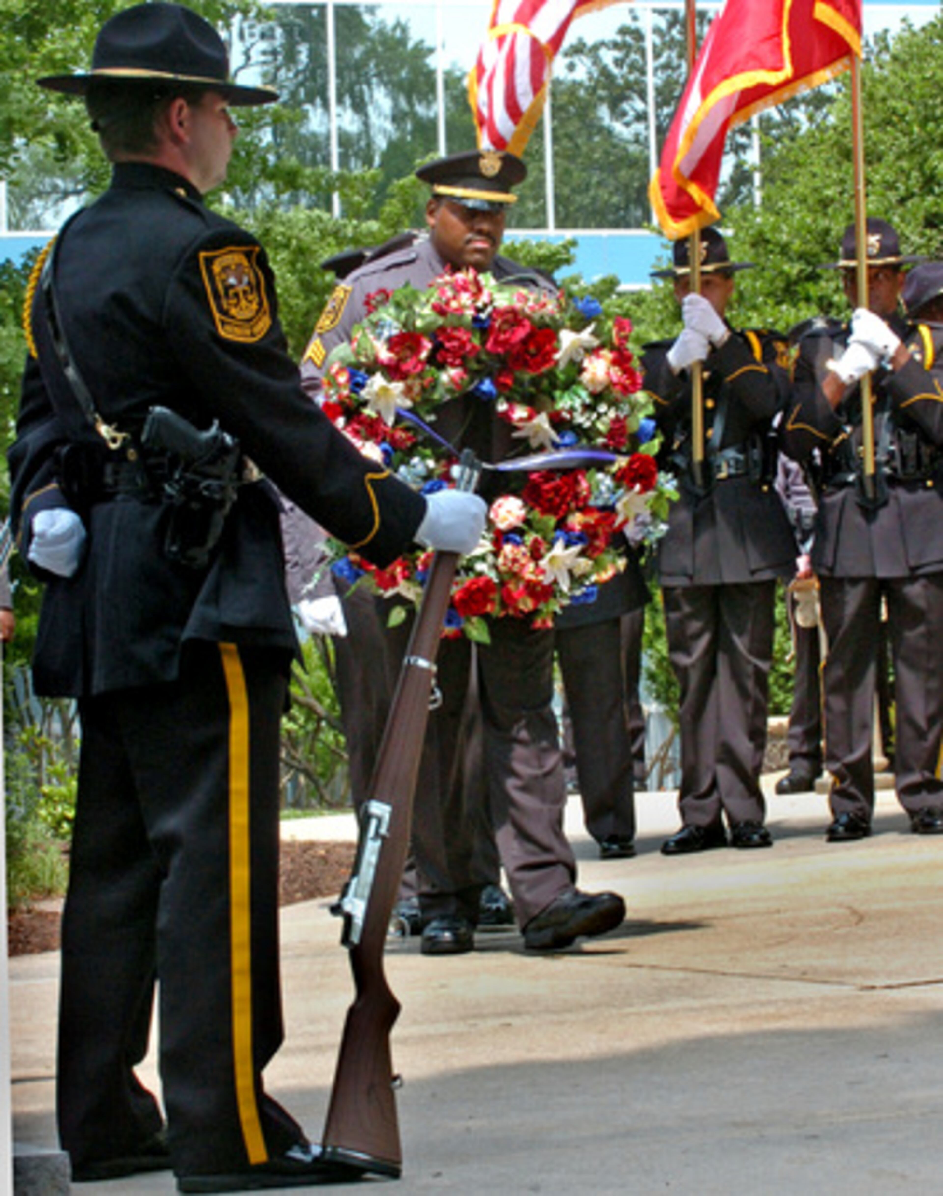 Officer M. Sarvis (left) of the DeKalb Police Honor Guard, stands as Sgt C.D. Swain (right) brings the wreath to be placed on the memorial.
