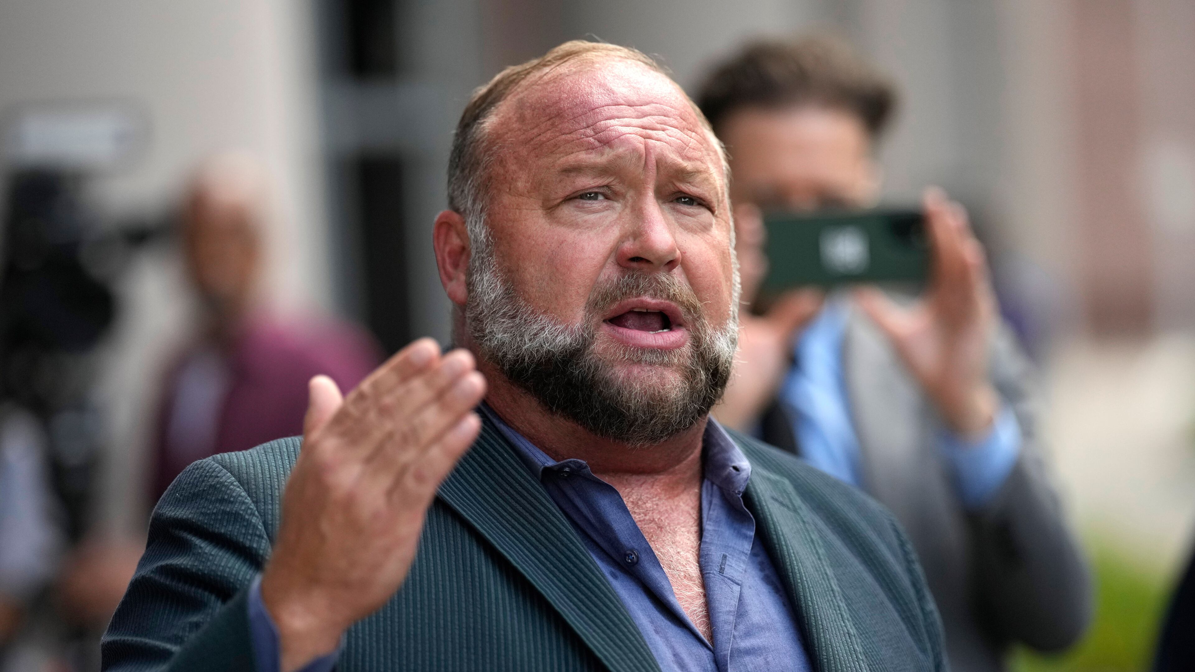FILE - Right-wing conspiracy theorist Alex Jones speaks to the media after arriving at the federal courthouse for a hearing in front of a bankruptcy judge, June 14, 2024, in Houston. (AP Photo/David J. Phillip, File)