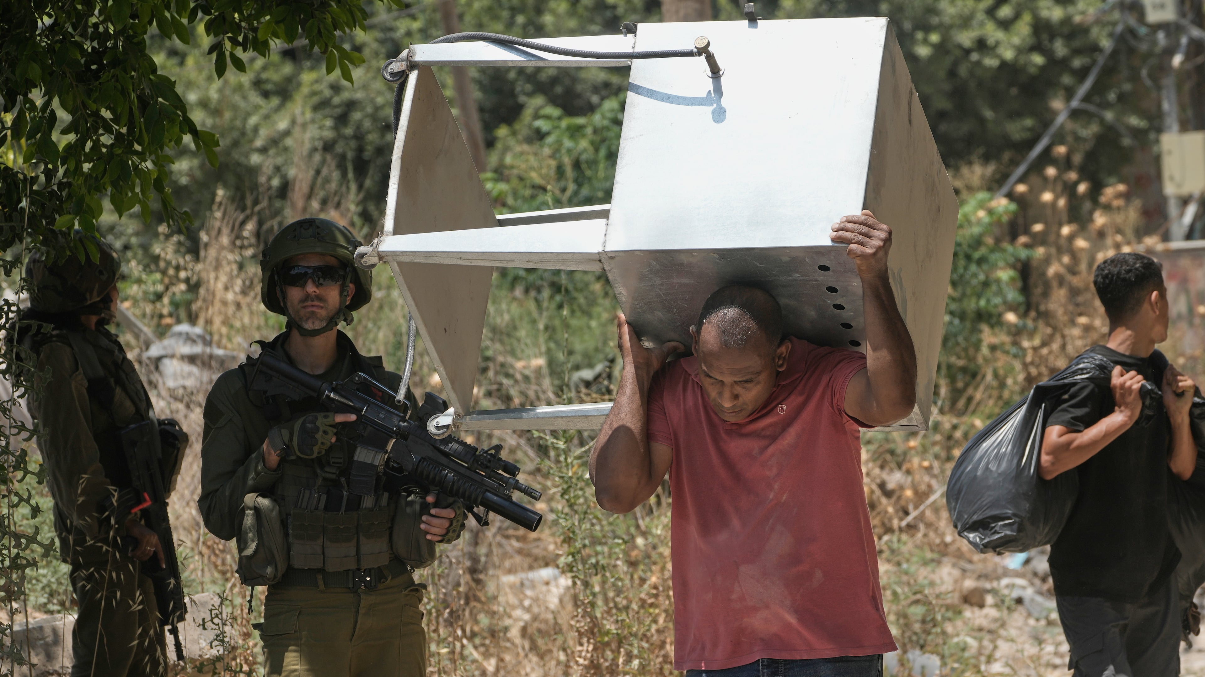 Palestinians collect their belongings from their evacuated homes after the Israeli army issued a number of short term access permits for residents of the occupied West Bank refugee camp of Tulkarem, Wednesday, June 17, 2026. (AP Photo/Majdi Mohammed)